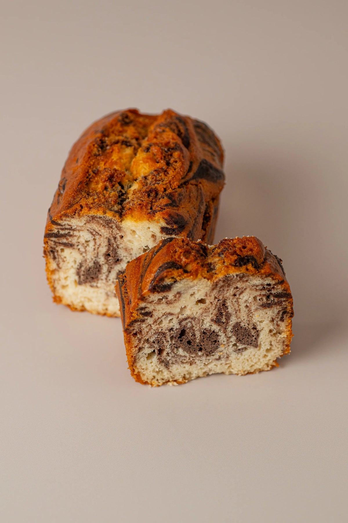 Bizcocho marmolado sin gluten y sin lactosa de NICOLINA Madrid, cortado para mostrar sus vetas de cacao y miga tierna.
