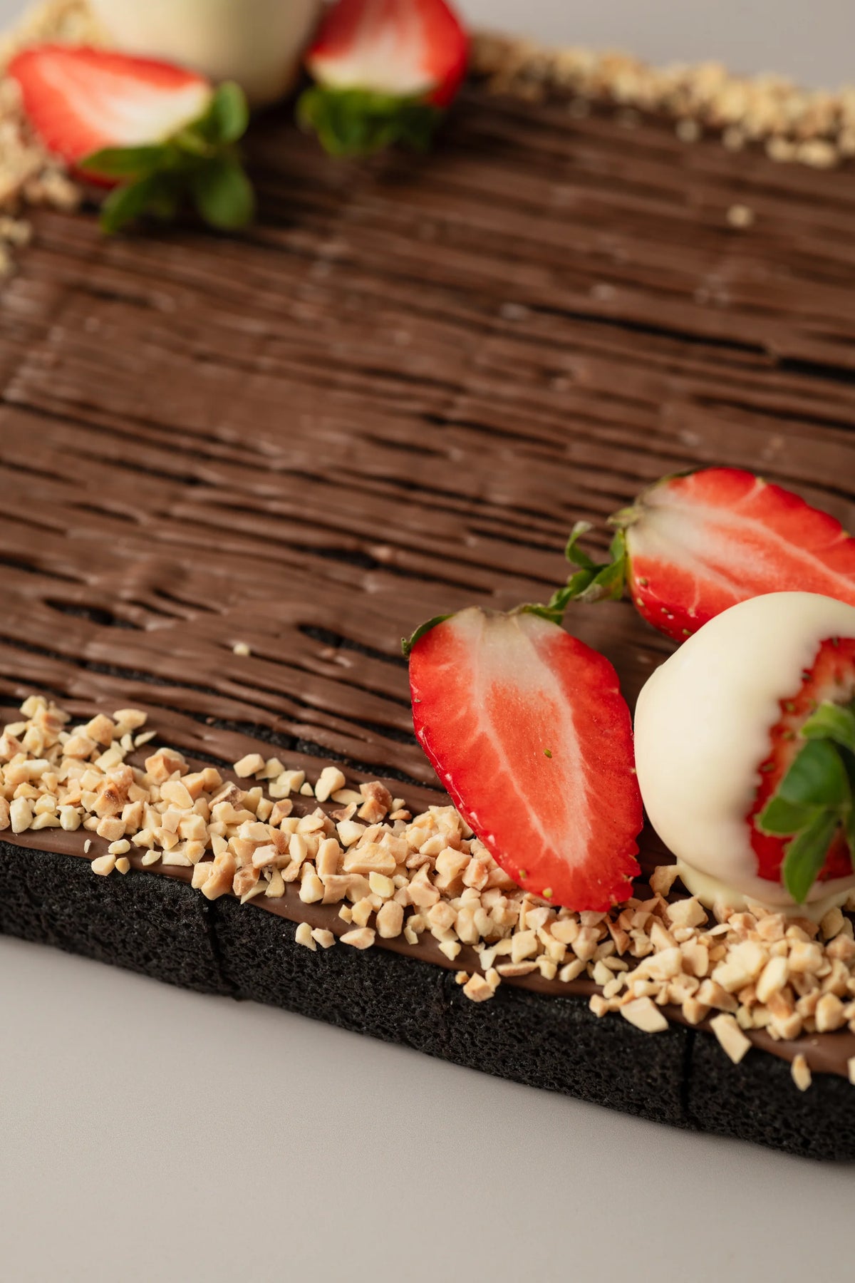 Detalle de brownie artesanal sin gluten, sin azúcar y sin lactosa con cobertura de nutelina y almendras.
