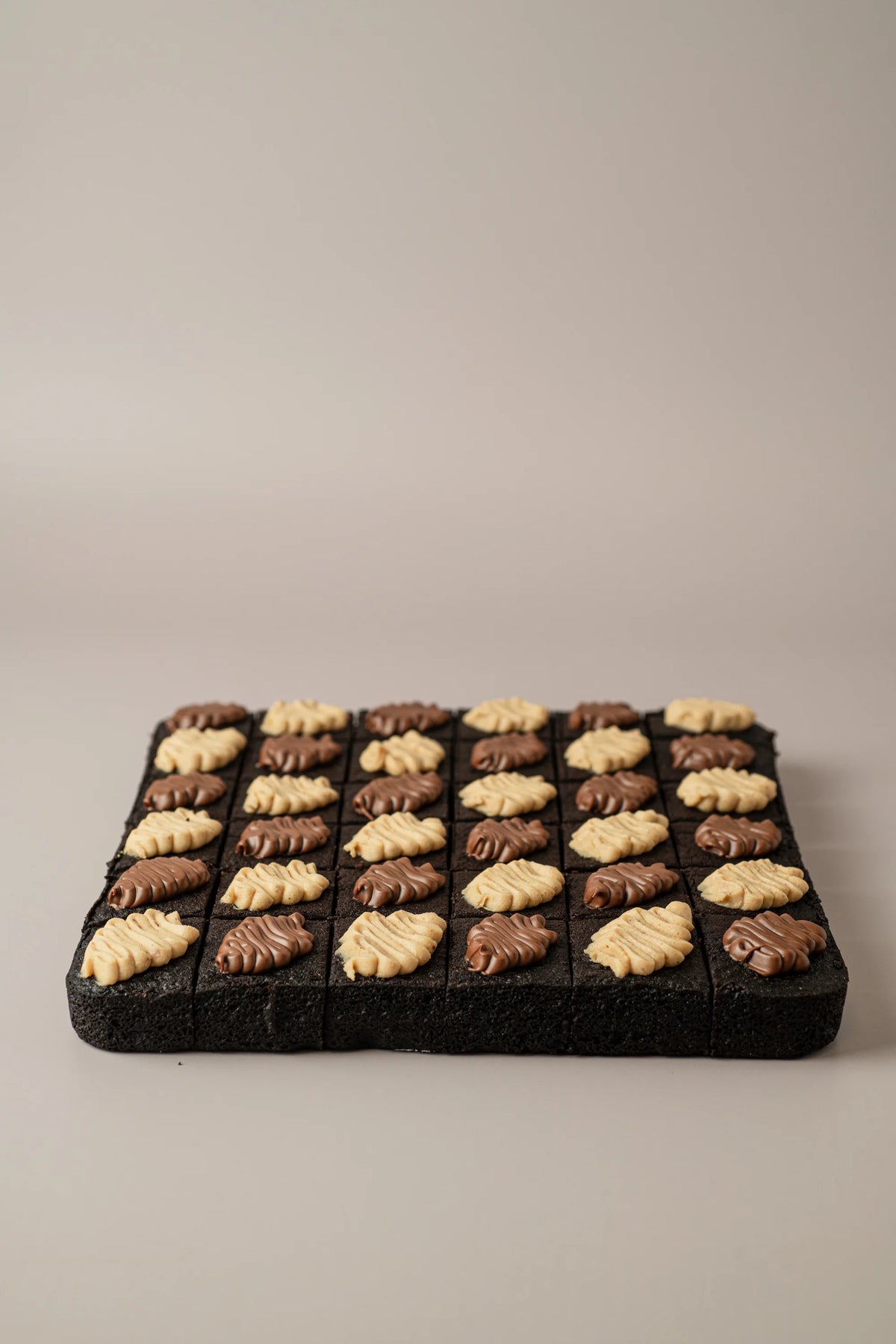 Brownies gourmet sin gluten, sin azúcar y sin lactosa decorados con nueces, pecanas y crema de chocolate.
