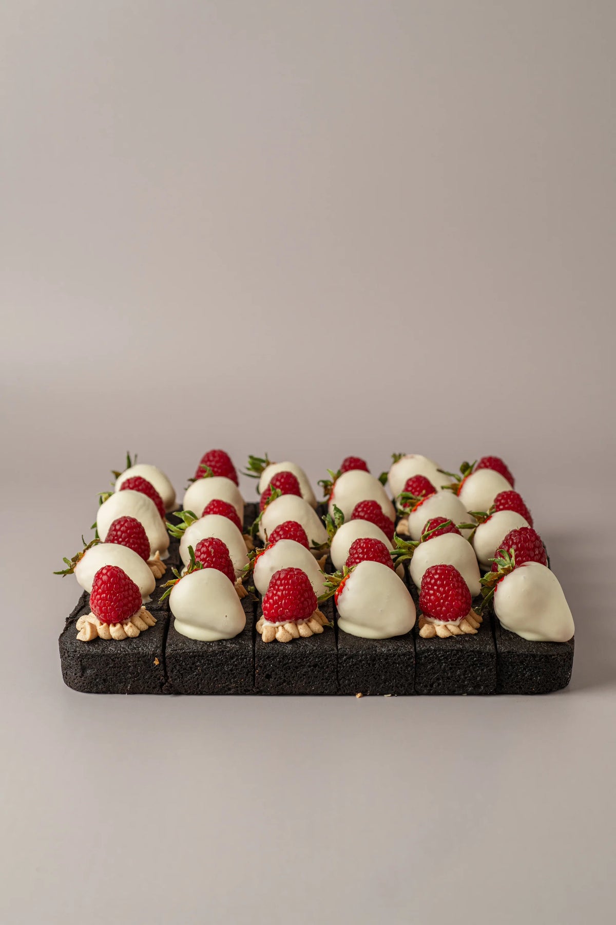 Brownies decorados sin gluten, sin azúcar y sin lactosa con fresas bañadas, crema kinder y frambuesas frescas.
