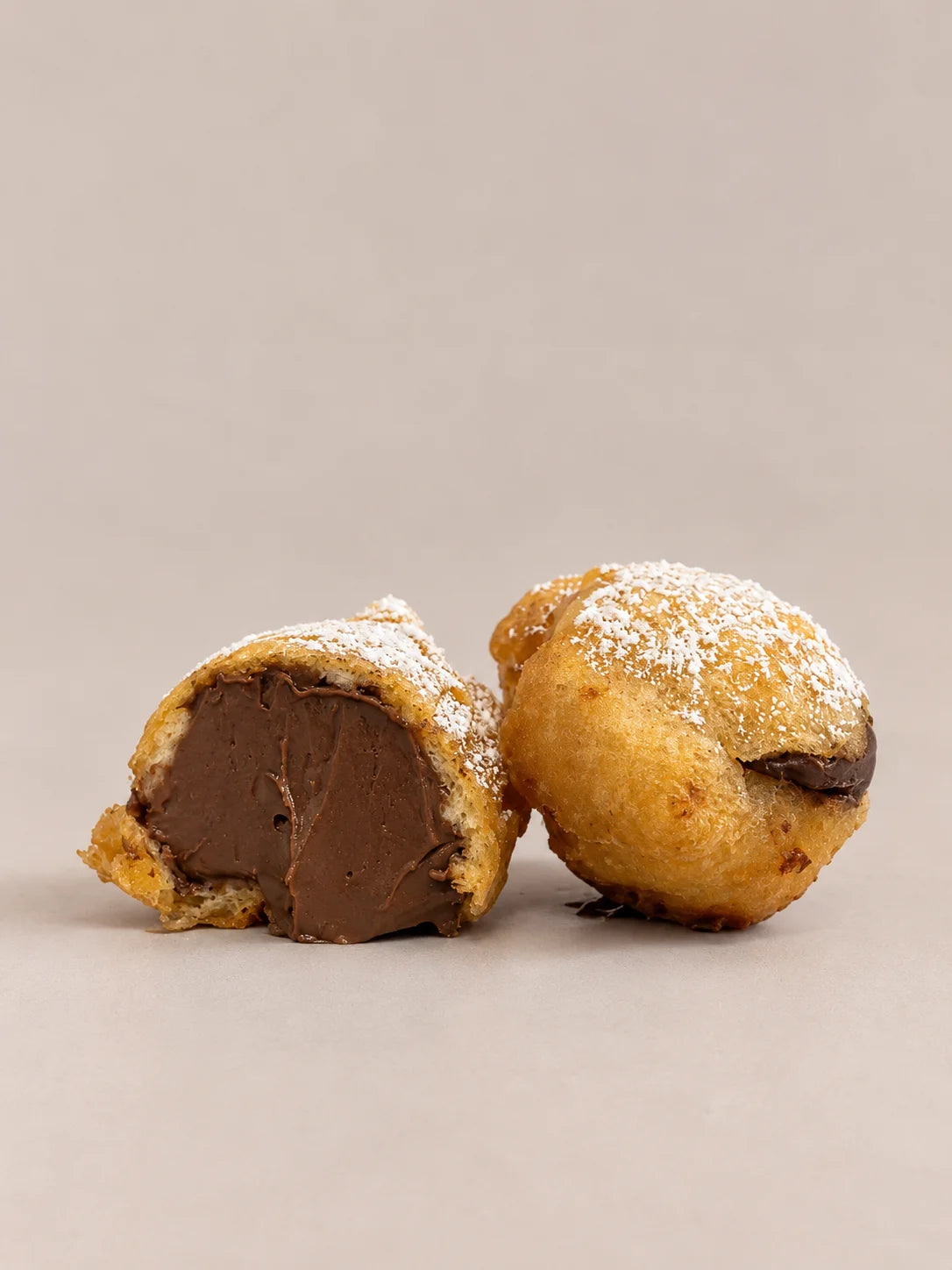Buñuelo de chocolate sin gluten y sin lactosa abierto, mostrando el abundante relleno de chocolate en su interior.