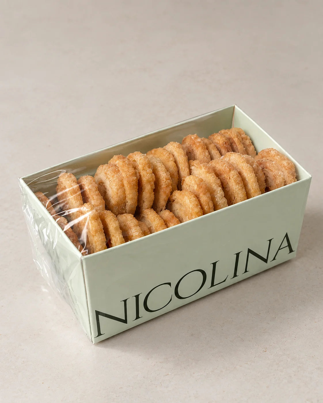 Caja de palmeritas de hojaldre sin gluten, sin lactosa y sin azúcar con textura crujiente y acabado artesanal.

