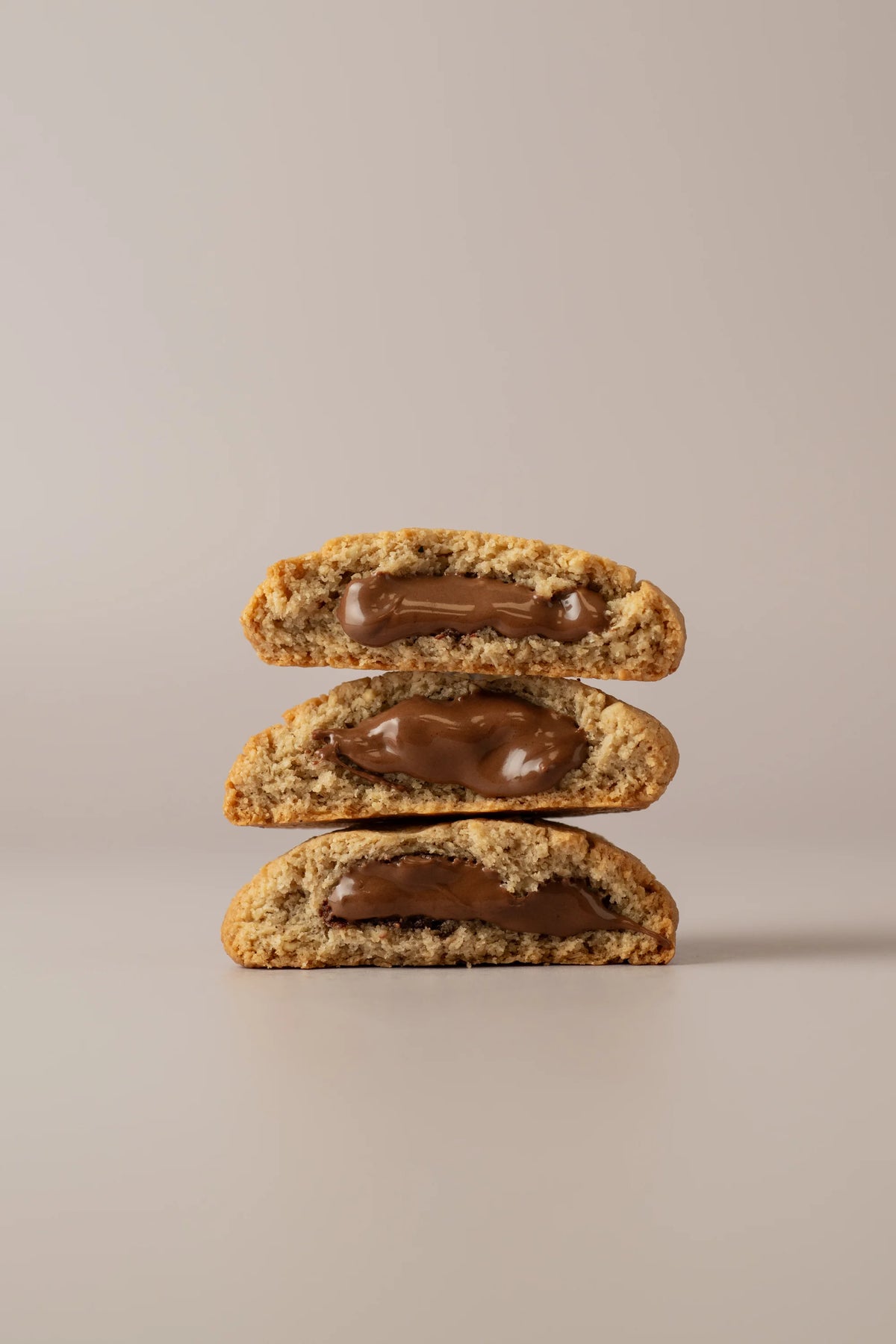 Cookie partida rellena de crema de chocolate con avellanas sin gluten y sin lactosa en pastelería artesanal de Madrid.
