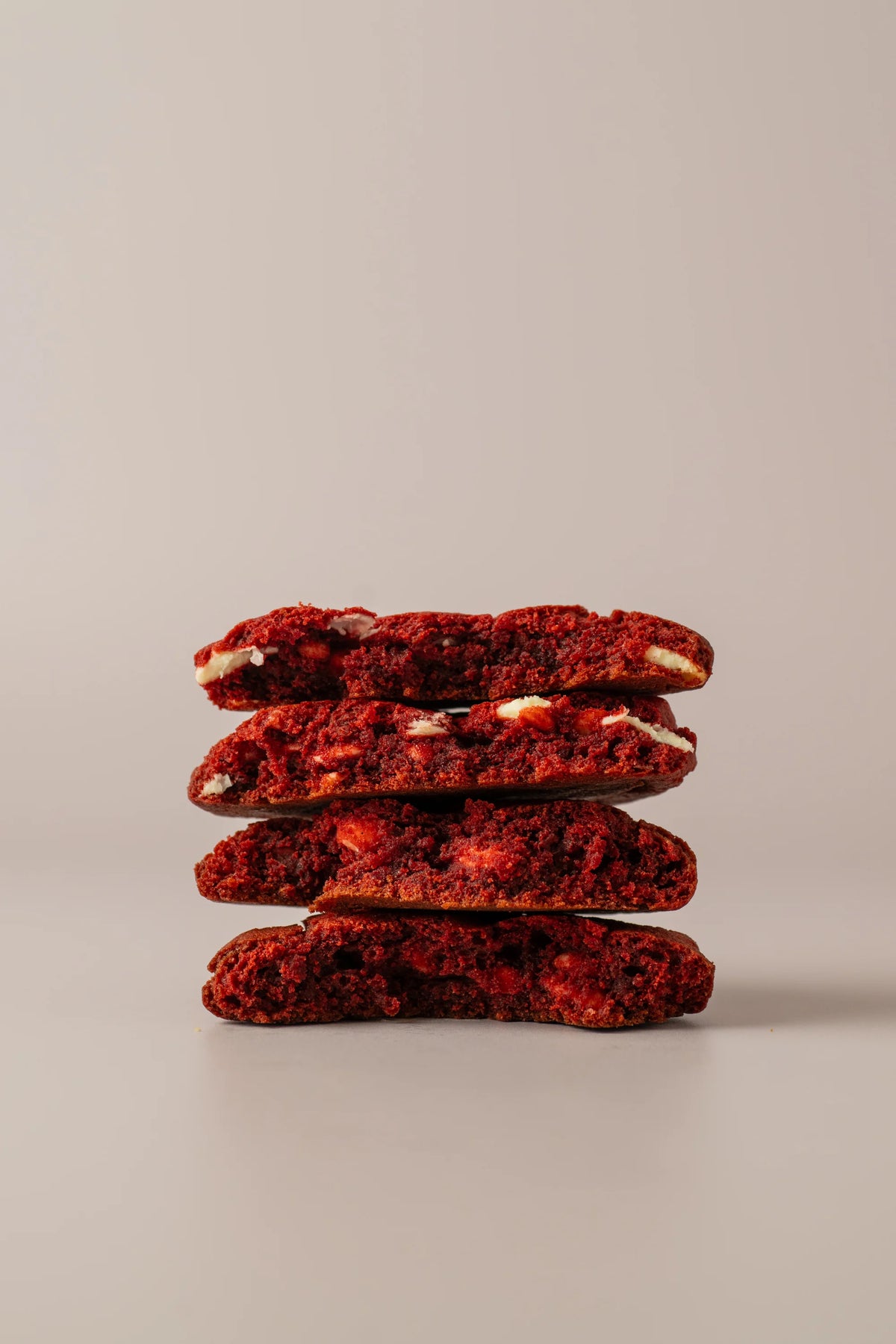Cookie red velvet sin gluten partida, con interior tierno y trozos cremosos, elaborada artesanalmente por NICOLINA en Madrid.
