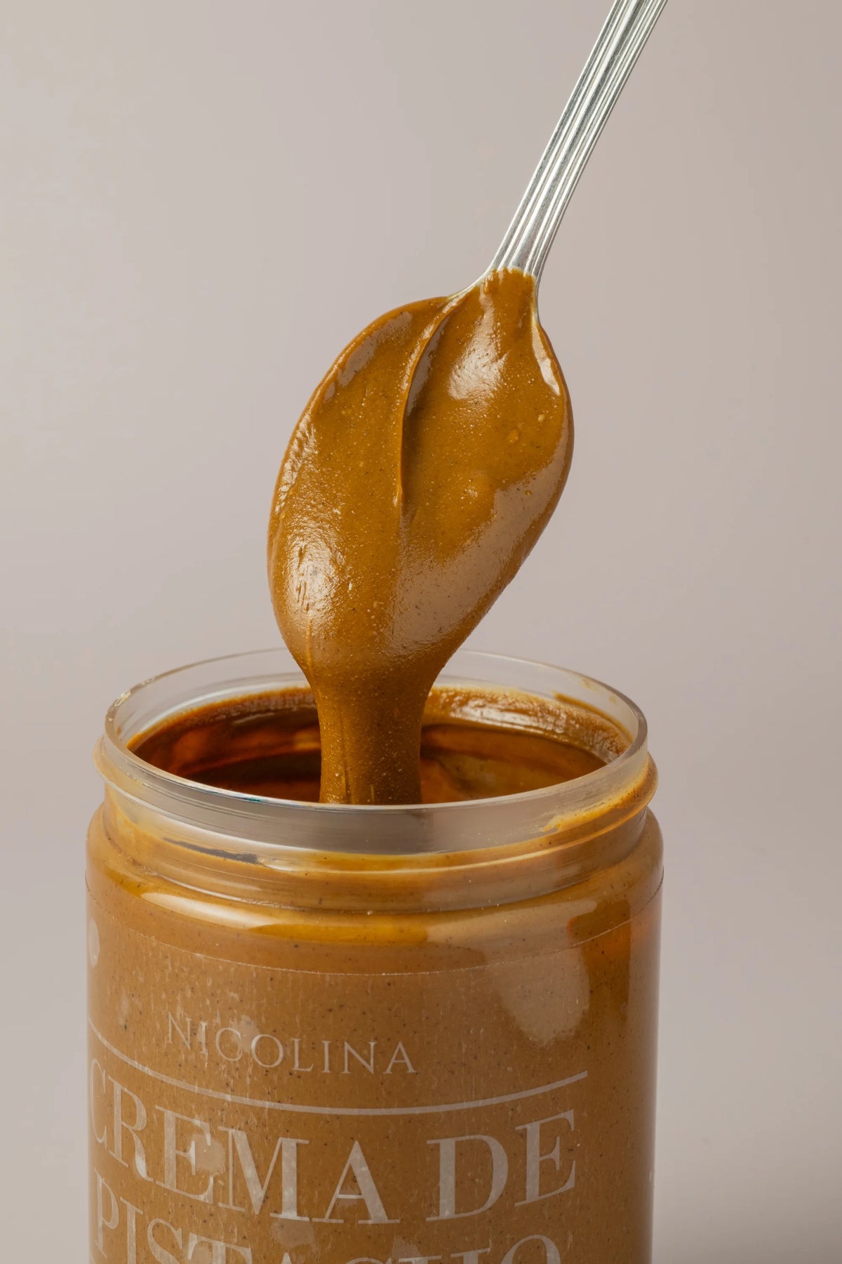 Detalle de crema de pistacho sin gluten y sin azúcar servida en cuchara con textura suave y cremosa.
