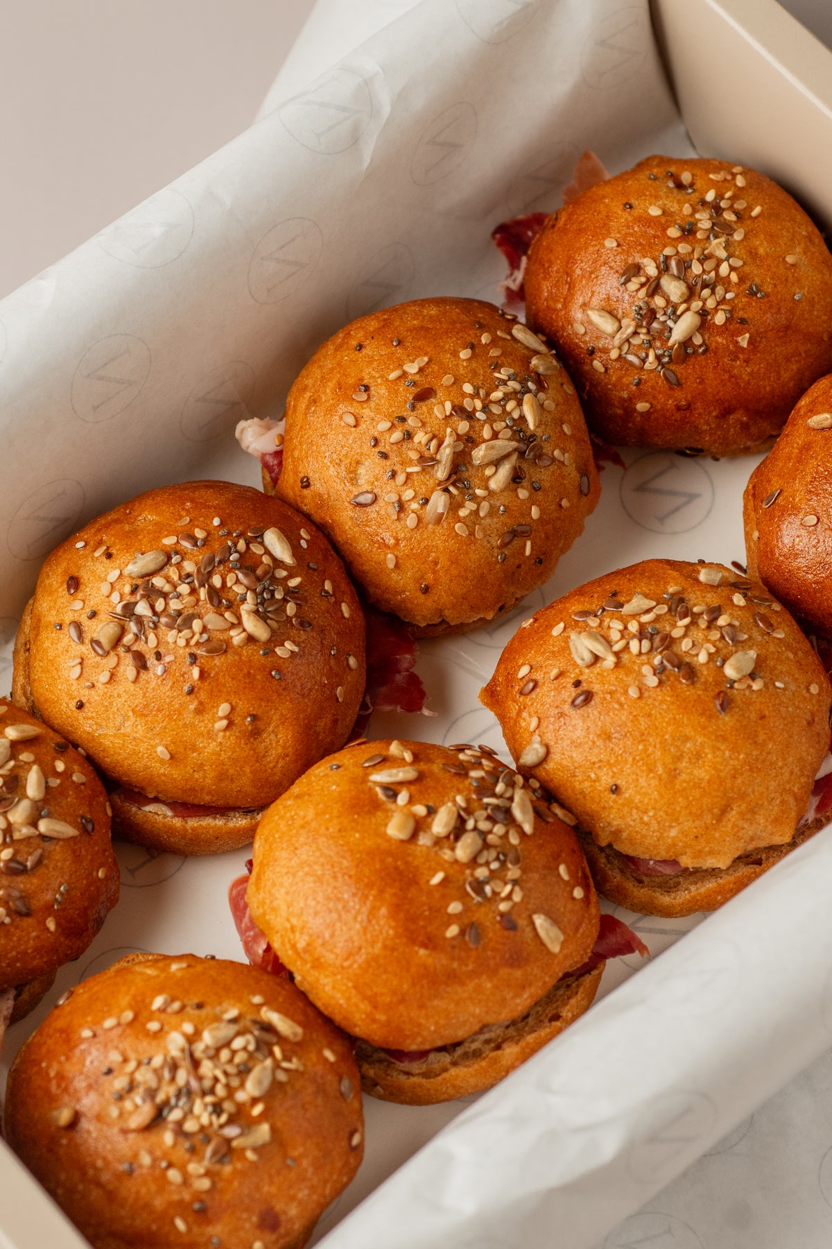 Detalle de brioches serranitos sin gluten de NICOLINA, con jamón serrano asomando.