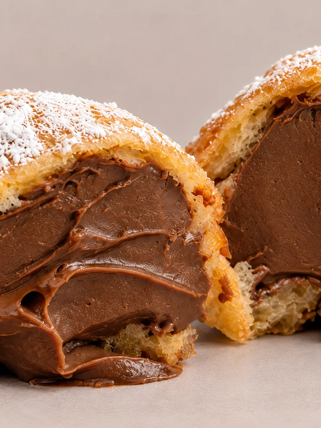Detalle de buñuelo de chocolate sin gluten y sin lactosa, con masa dorada y tierna y abundante relleno de chocolate.