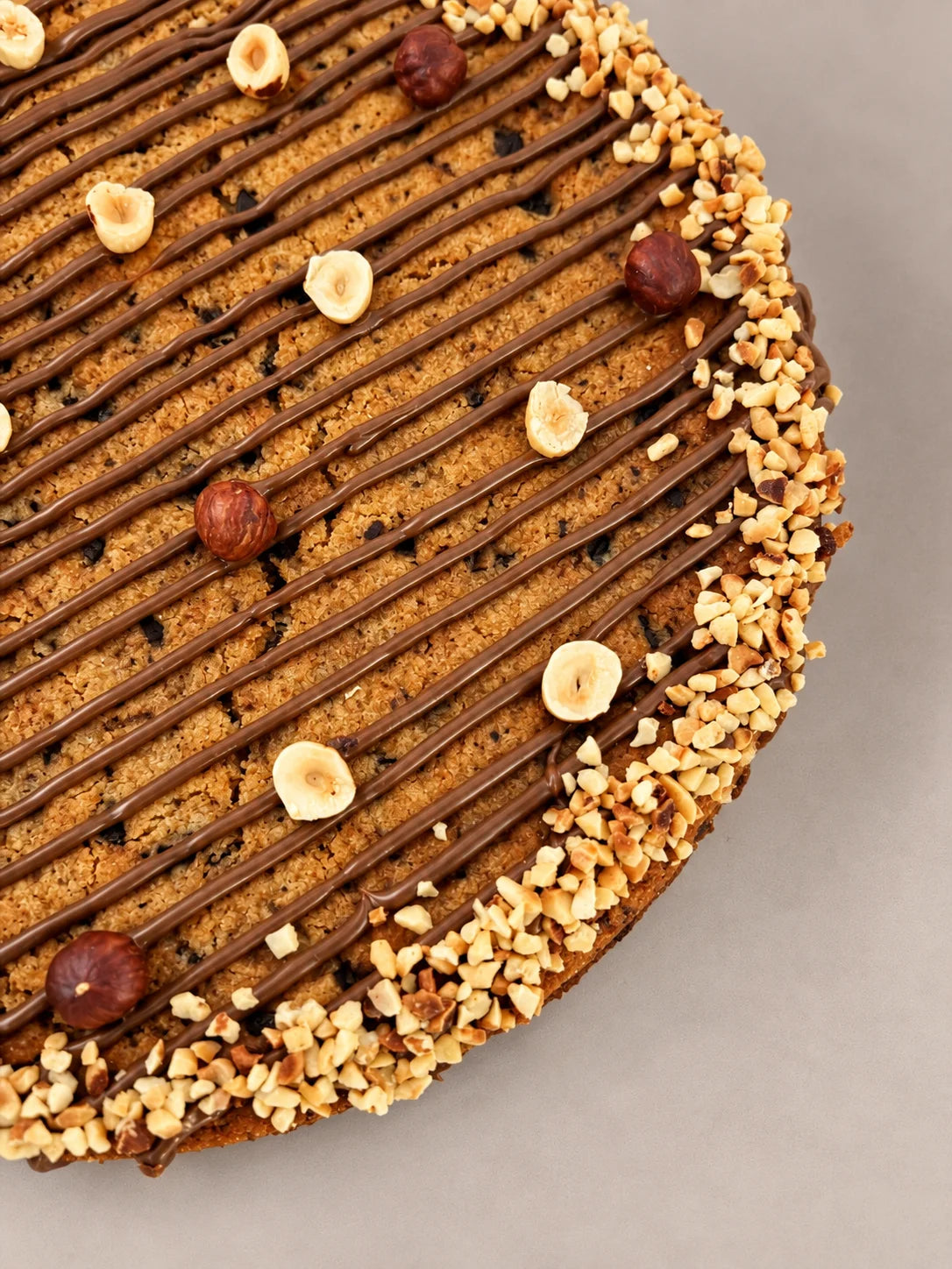 Detalle interior de cookie XXL de chocolate y avellanas sin gluten y sin lactosa de NICOLINA Madrid, con chocolate fundido y textura tierna artesanal.
