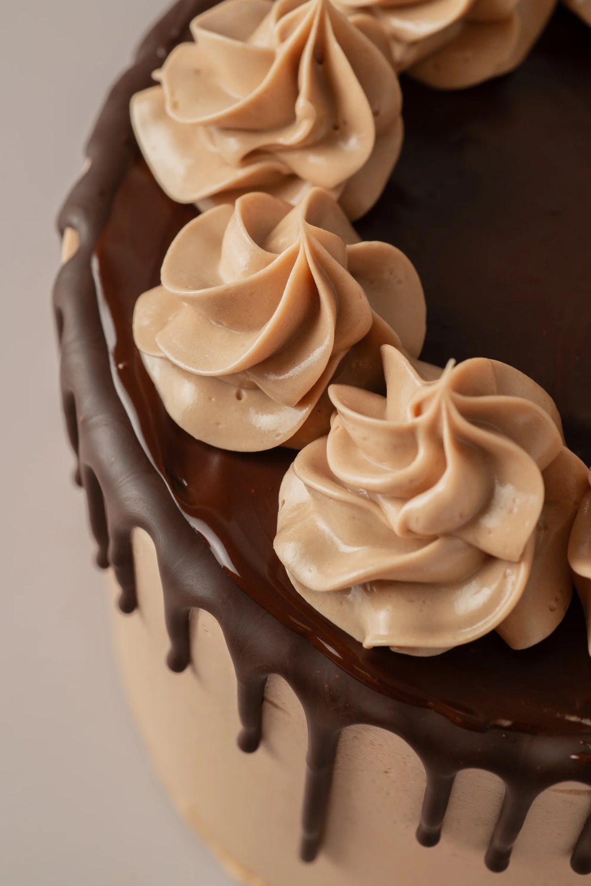 Tarta artesanal sin gluten y sin azúcar con acabado drip de chocolate y crema suave decorativa.
