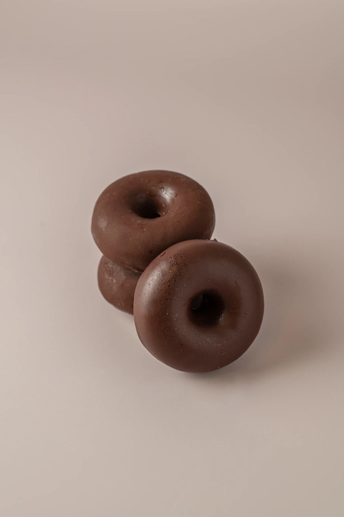 Detalle de donat artesanal de chocolate con acabado cremoso y cobertura de cacao.