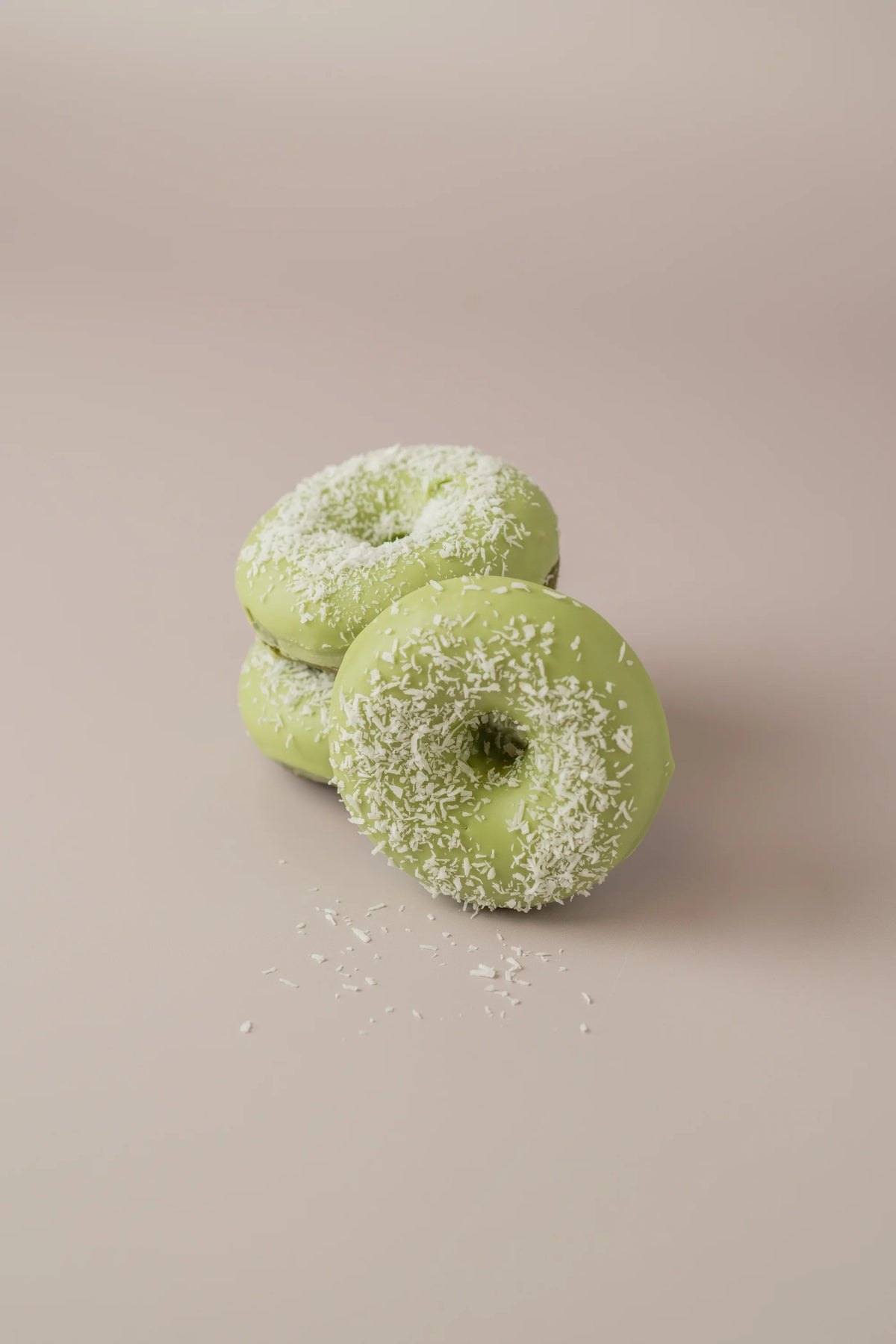 Donat matcha sin gluten y sin azúcar de NICOLINA Madrid con cobertura de chocolate blanco y coco rallado.