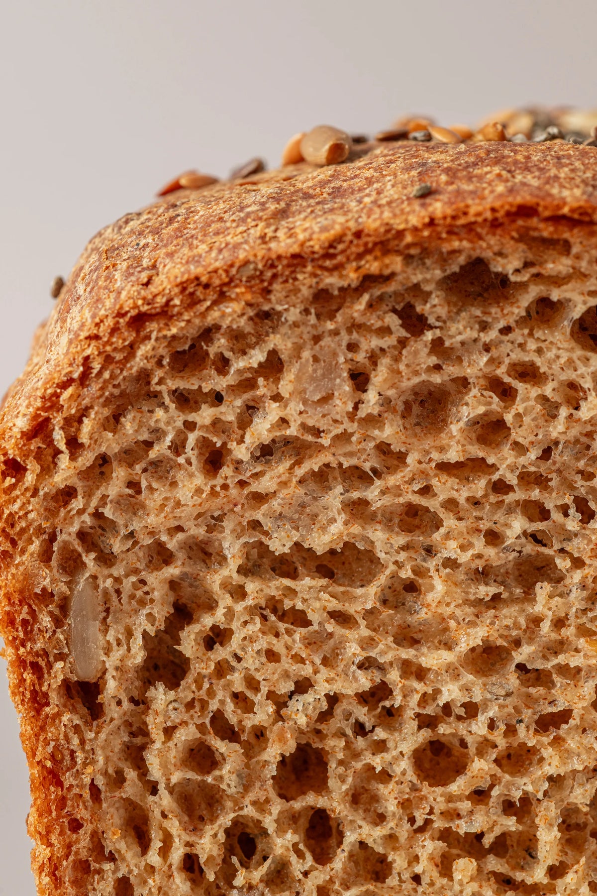 Detalle de la miga del pan de molde con semillas sin gluten y sin lactosa, textura tierna y esponjosa.
