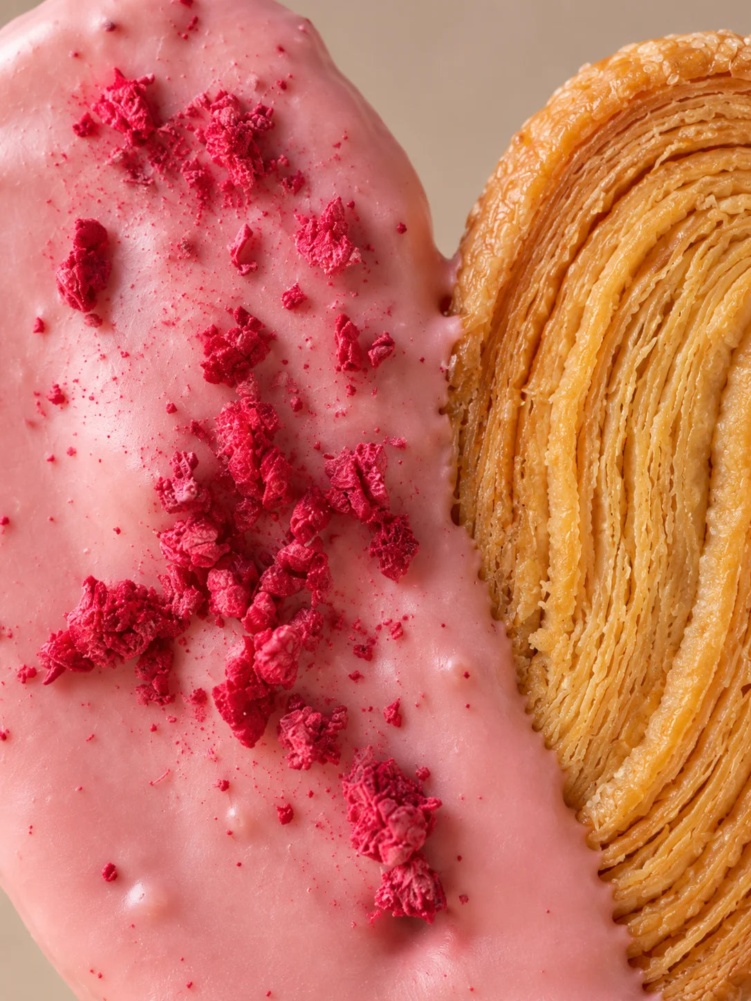 Detalle de palmera sin gluten de chocolate blanco y frambuesa con textura crujiente de hojaldre artesanal.