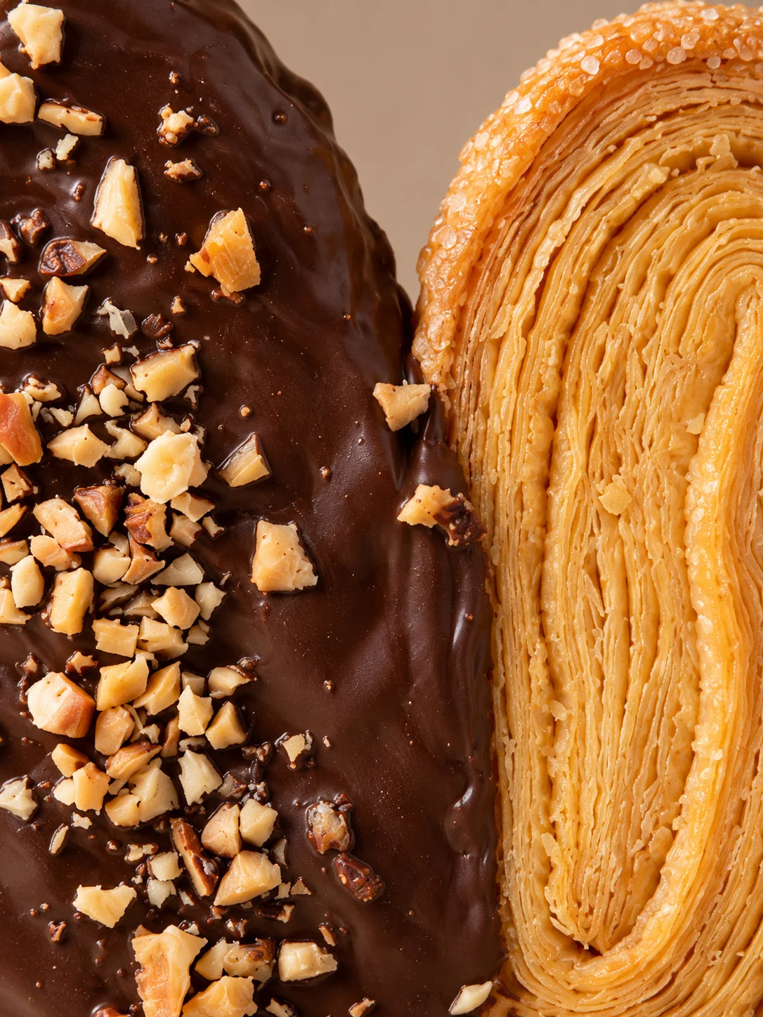 Detalle de palmera sin gluten y sin lactosa con capas finas de hojaldre, chocolate y almendra troceada.
