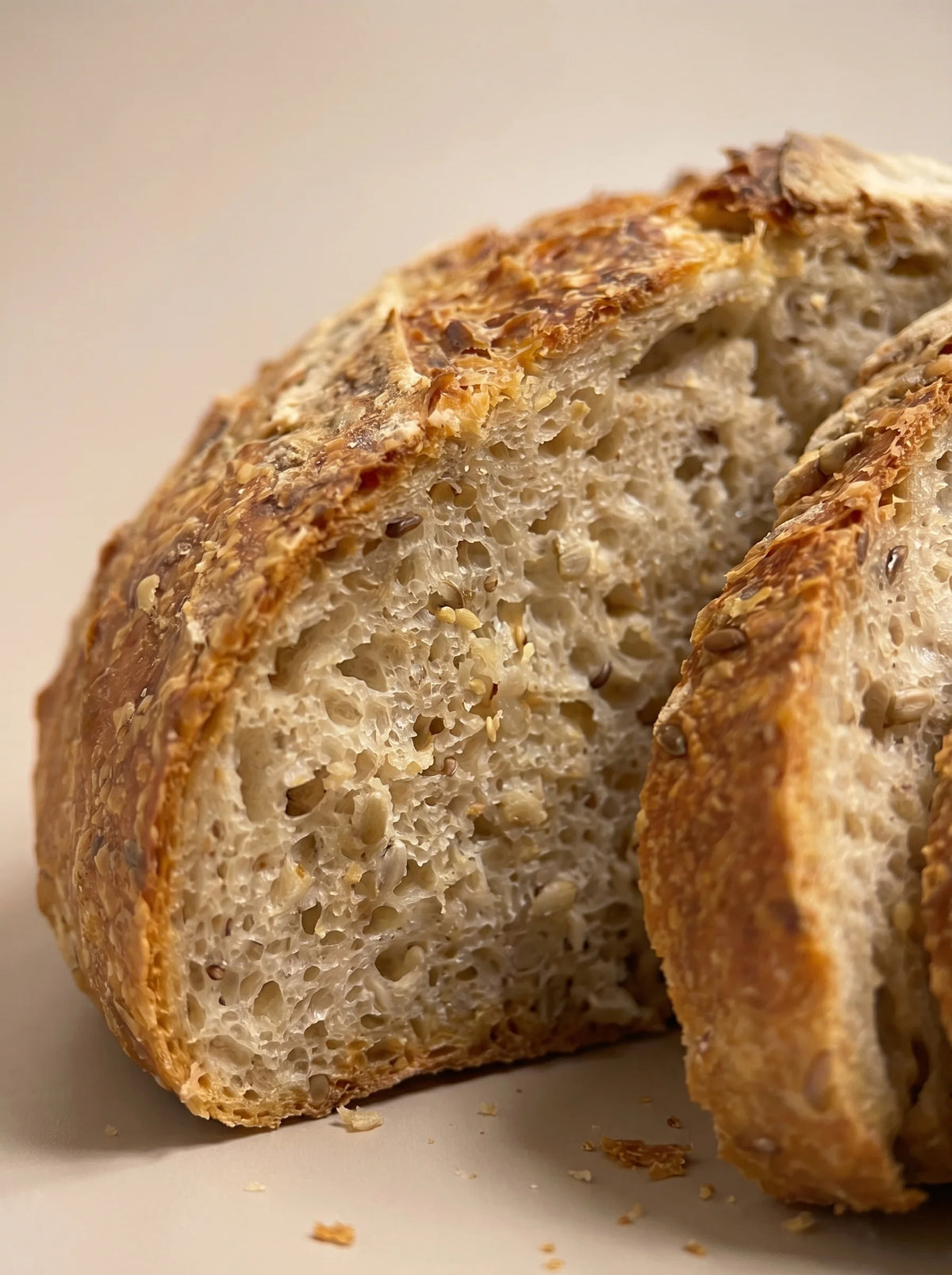 Interior de hogaza de semillas sin gluten y sin lactosa con miga tierna, alveolada y semillas.
