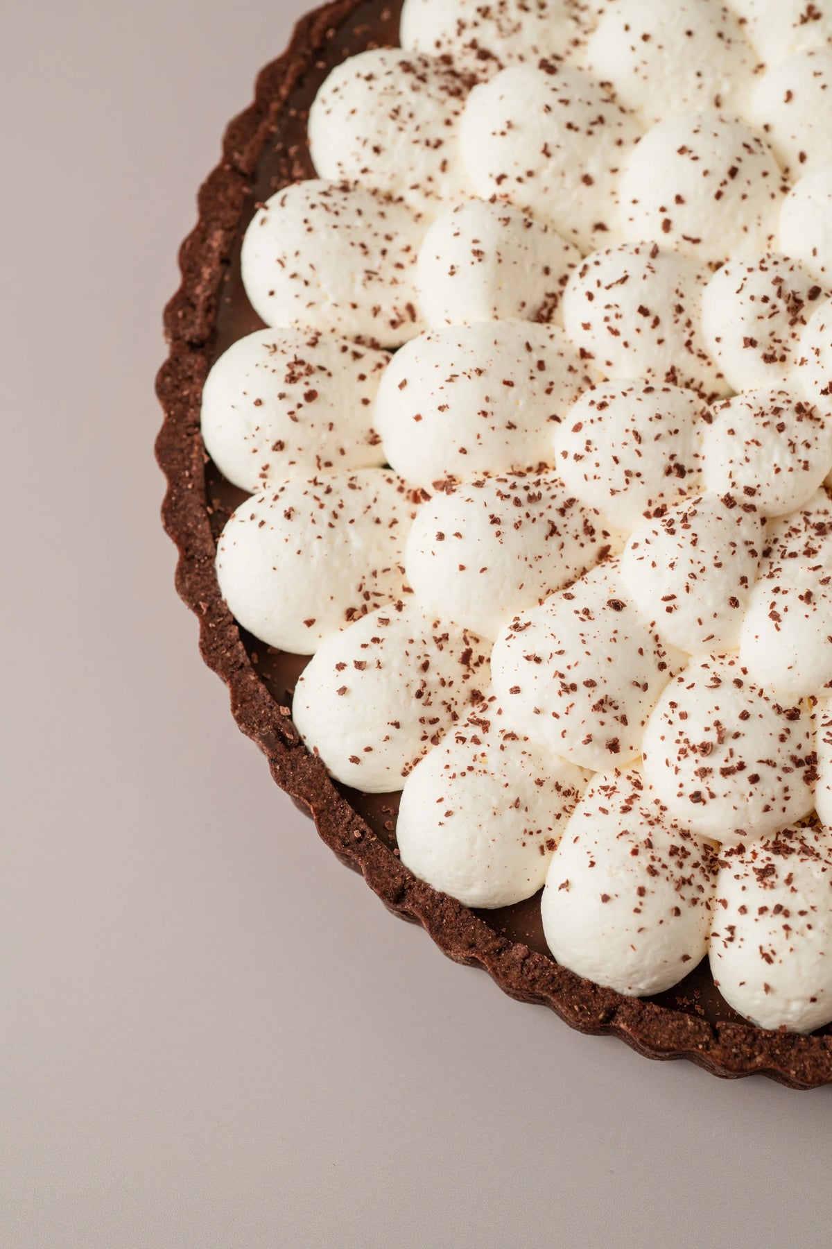 Detalle de tarta de chocolate y nata de NICOLINA Madrid con nata montada cremosa y virutas de chocolate.
