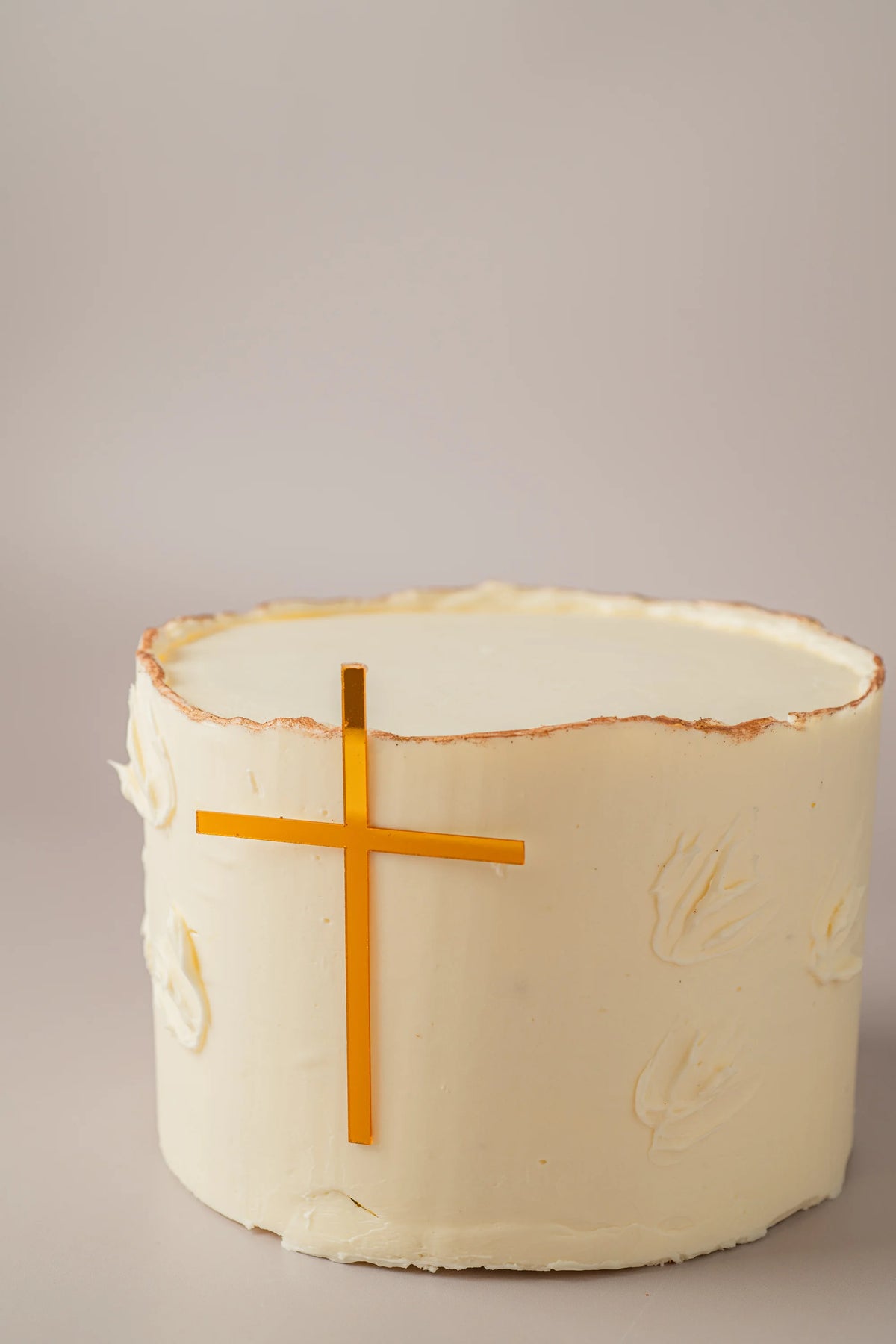 Primer plano de tarta artesanal de Primera Comunión sin gluten con textura cremosa y decoración elegante.
