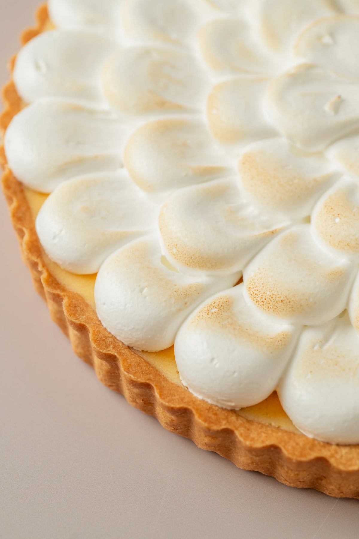 Detalle de tarta de limón artesanal de NICOLINA Madrid, con merengue tostado y base crujiente sin gluten.
