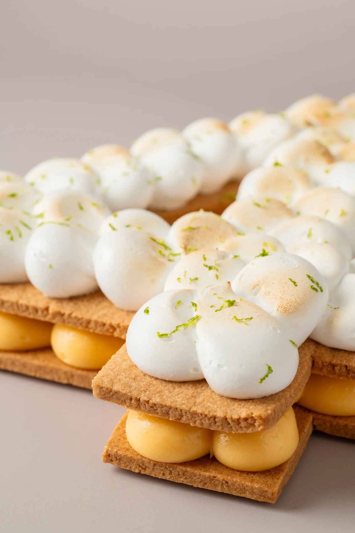 Primer plano de tarta número de limón sin gluten, sin azúcar y sin lactosa con galleta crujiente y merengue artesanal.
