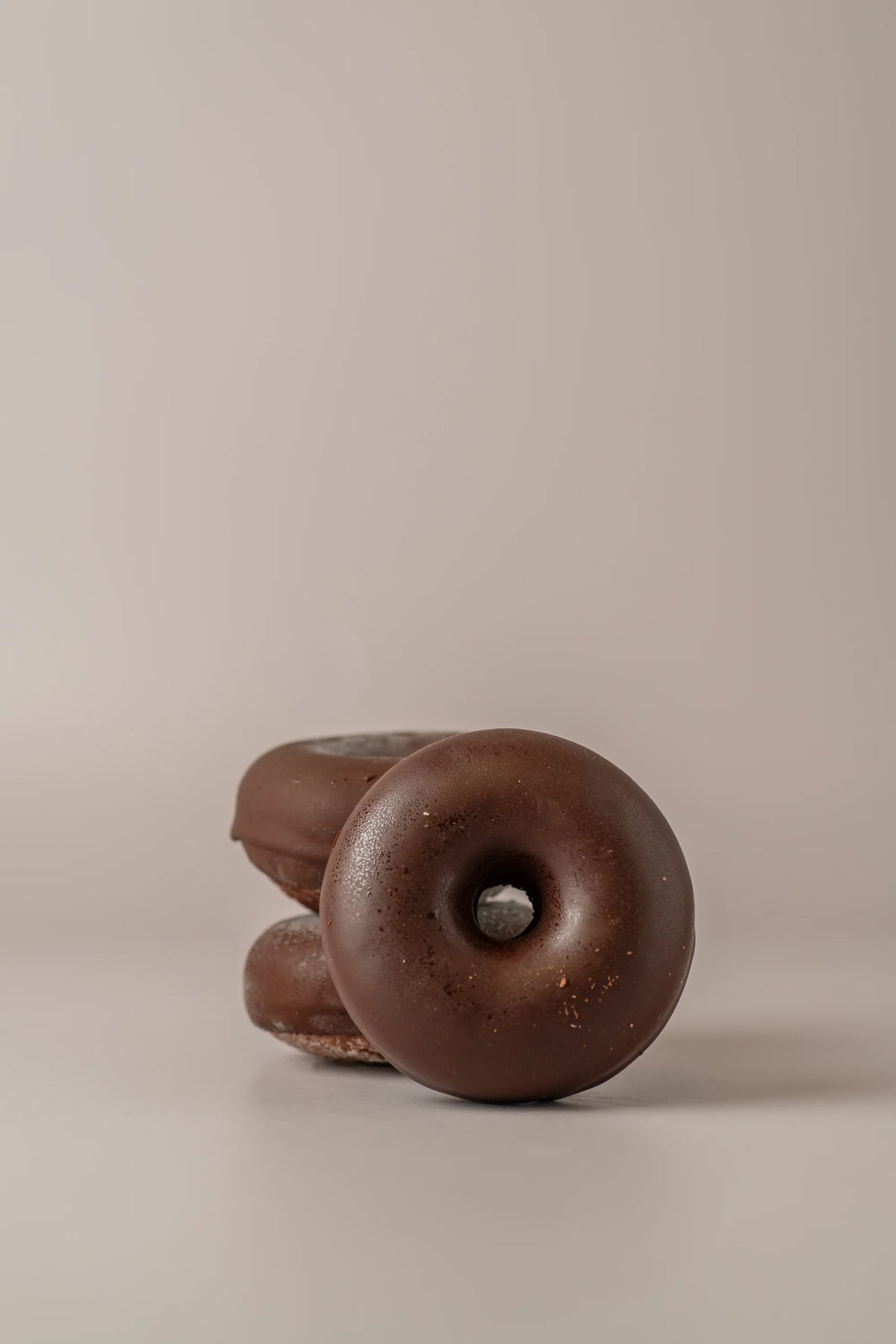 Donat de cacao artesanal sin gluten y sin azucar de NICOLINA Madrid con cobertura intensa de chocolate.