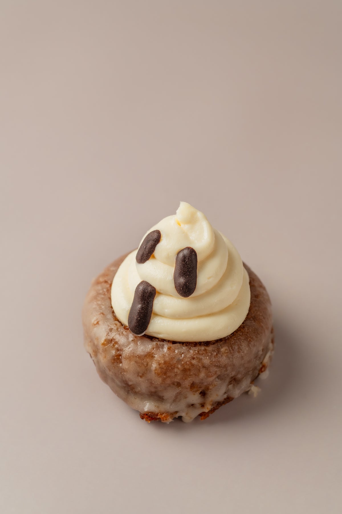 Donat Carrot Cake sin gluten de NICOLINA Madrid, decorado como un fantasma con frosting de crema y ojos de chocolate.