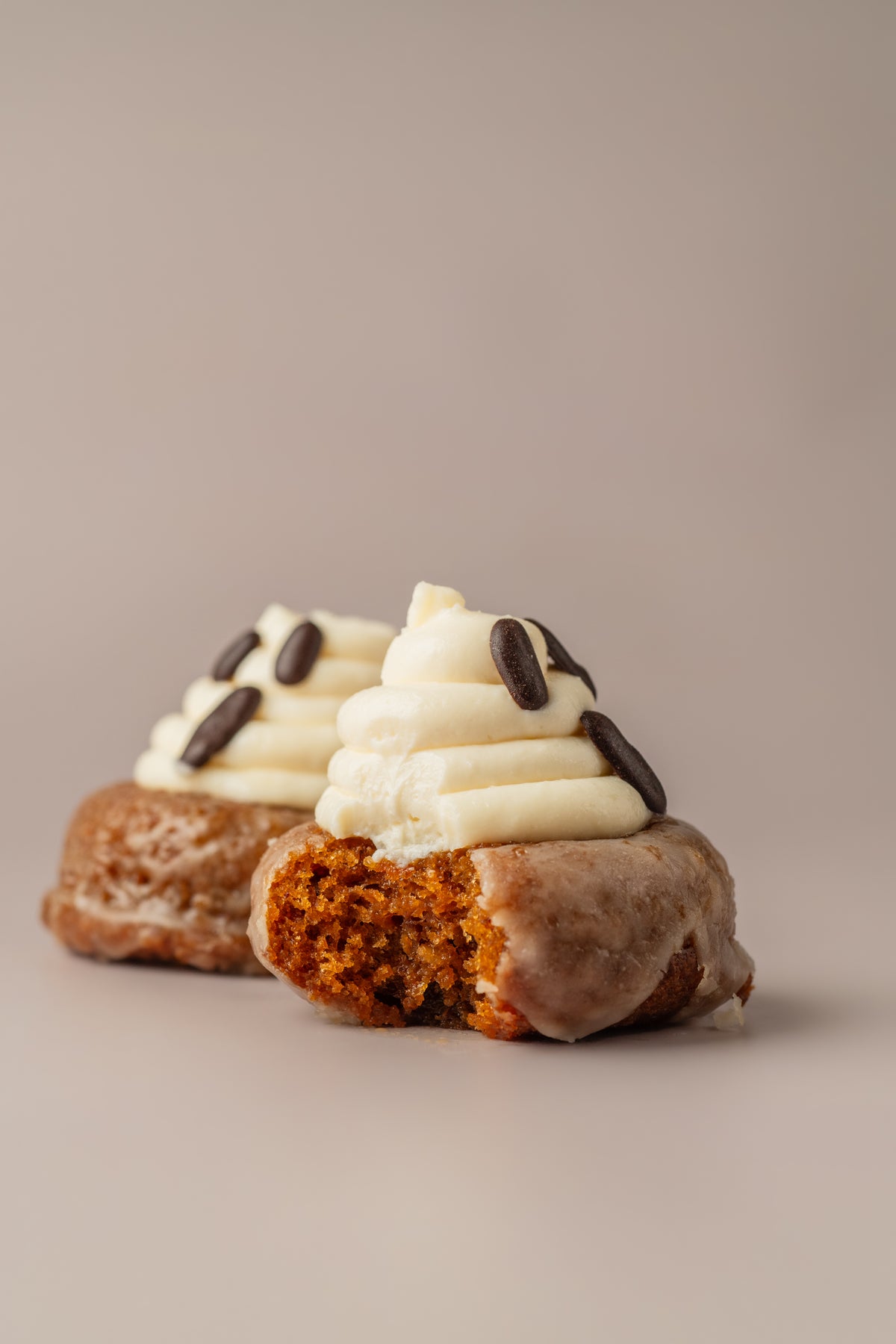 Donat Carrot Cake mordido, con el interior esponjoso de zanahoria y especias, de NICOLINA Madrid.