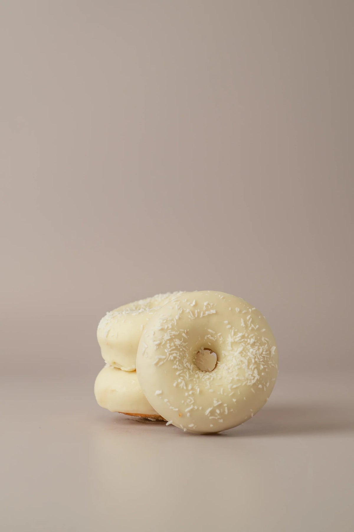 Donat de coco artesanal sin gluten y sin azucar de NICOLINA Madrid con cobertura de chocolate blanco y coco rallado.