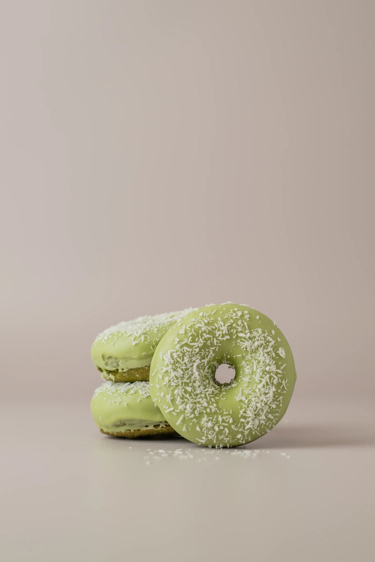 Detalle de donat matcha artesanal sin gluten y sin azúcar con chocolate blanco y coco.