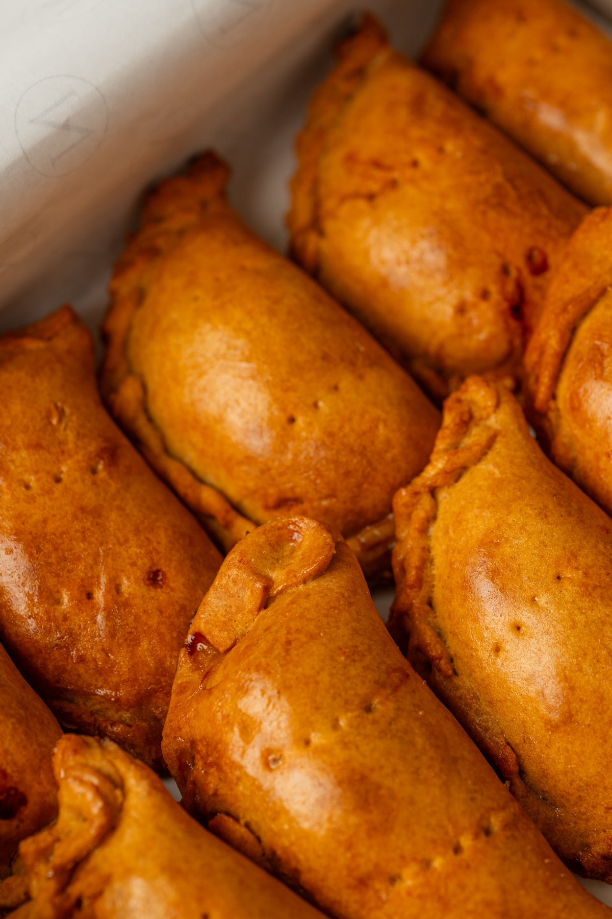 Empanadillas sin gluten doradas de NICOLINA Madrid, con su borde repulgado.