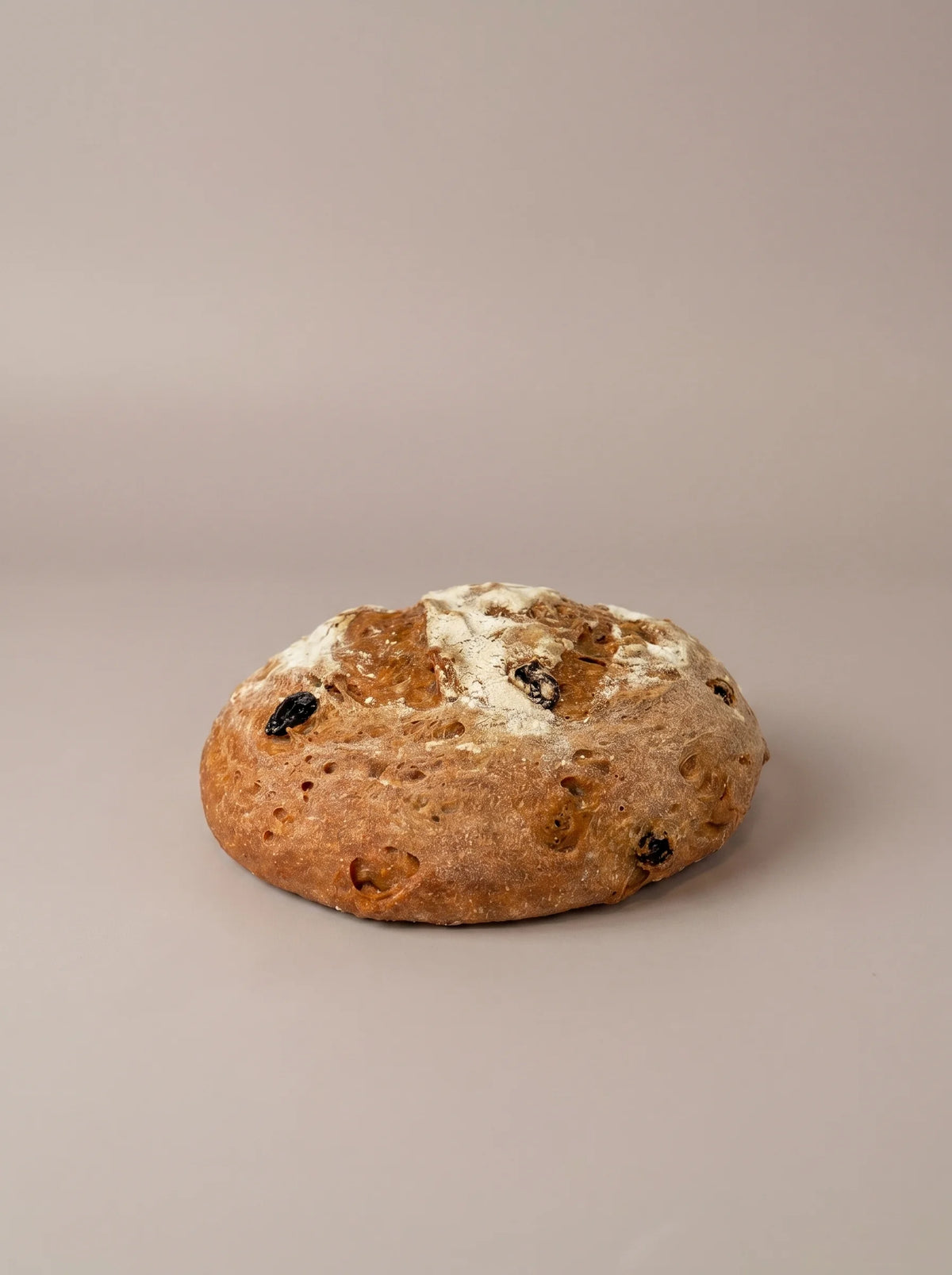 Hogaza artesanal de pasas y nueces sin gluten y sin lactosa con corteza crujiente y miga esponjosa con frutos secos.
