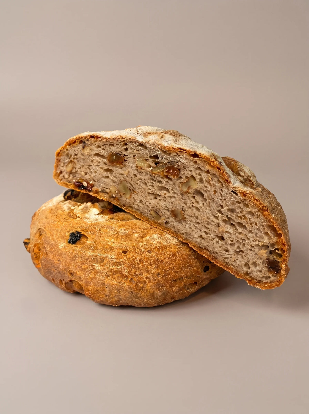 Hogaza de pasas y nueces sin gluten y sin lactosa cortada en rebanadas con interior esponjoso y textura artesanal.
