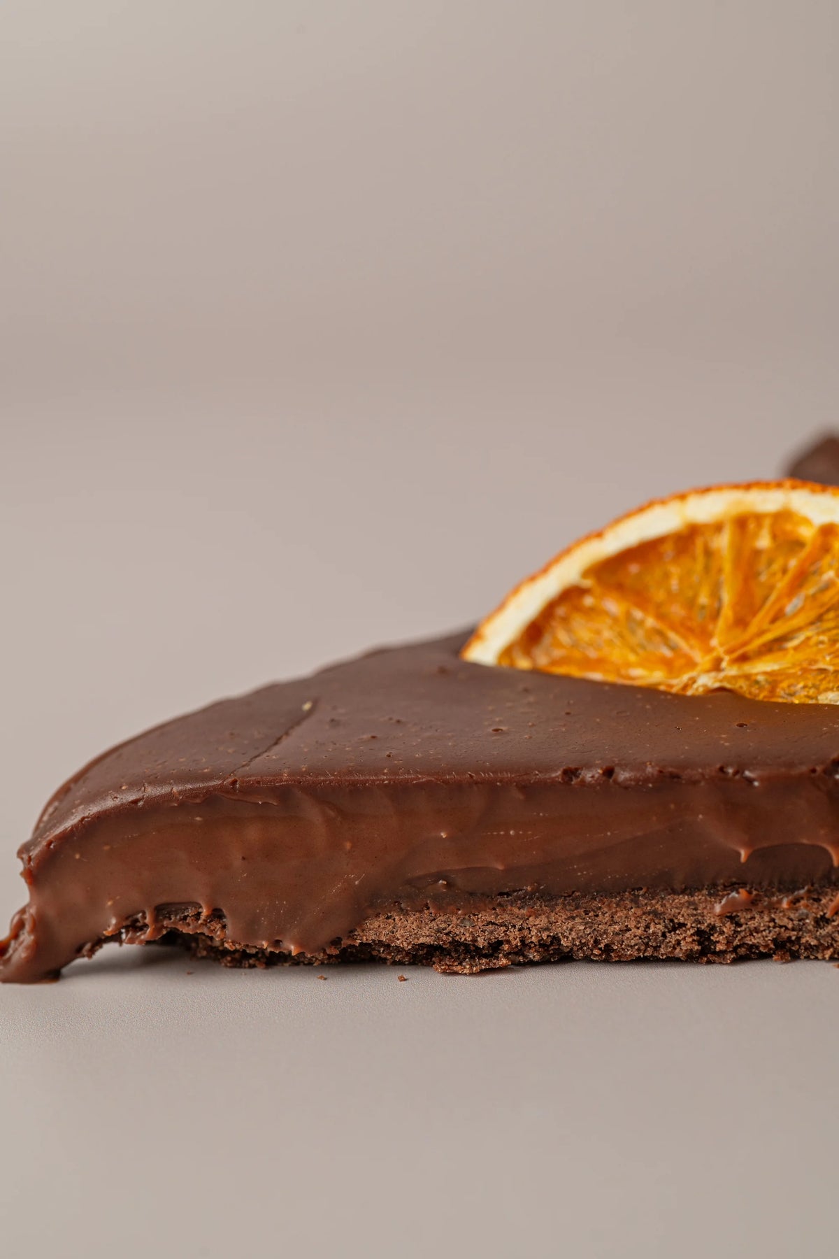 Detalle interior de tarta de chocolate y naranja artesanal de NICOLINA Madrid, con cremoso de chocolate y base sablé de cacao.
