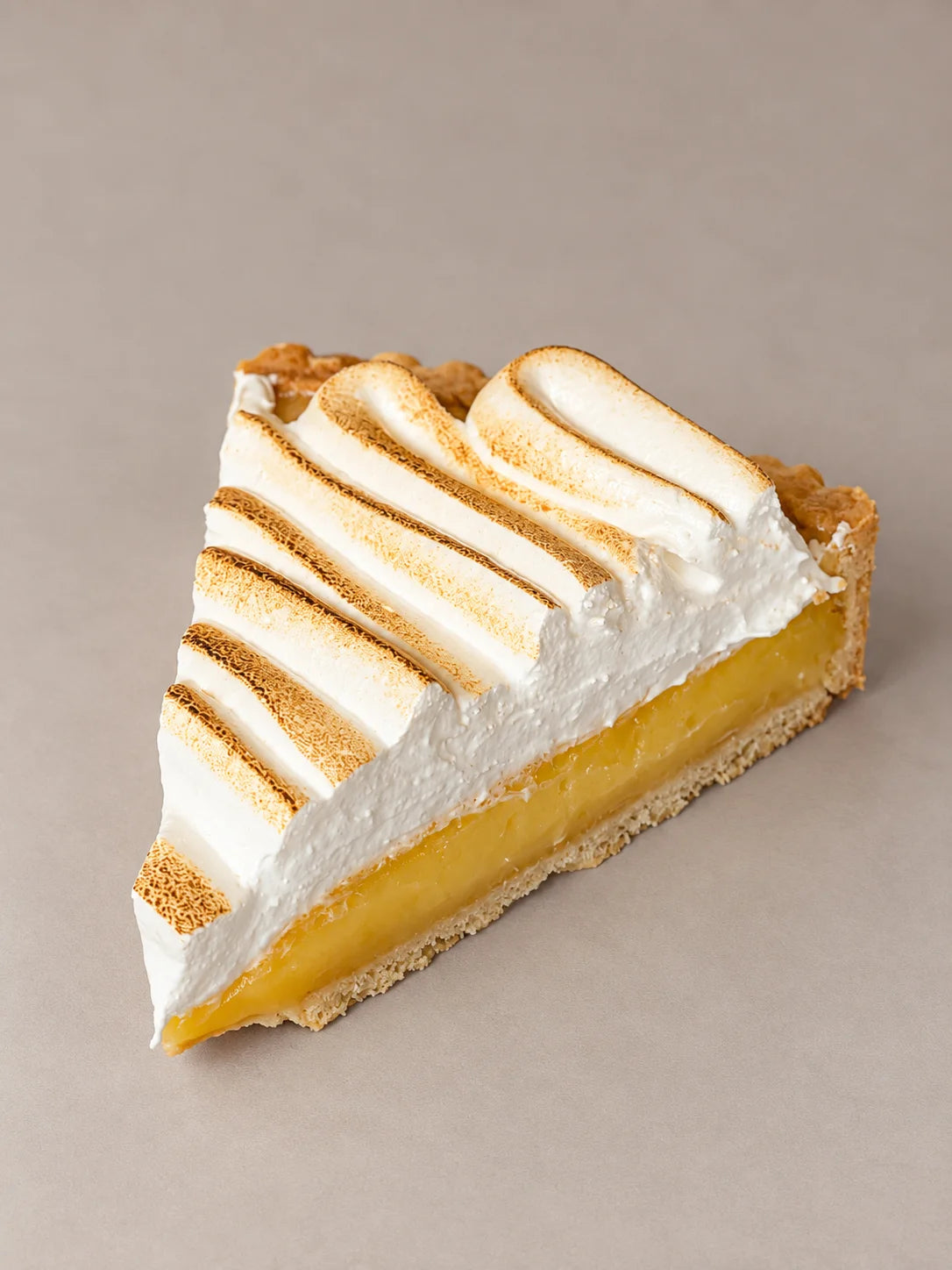 Detalle de tarta artesanal de maracuyá de NICOLINA Madrid, con merengue tostado y base crujiente sin gluten.
