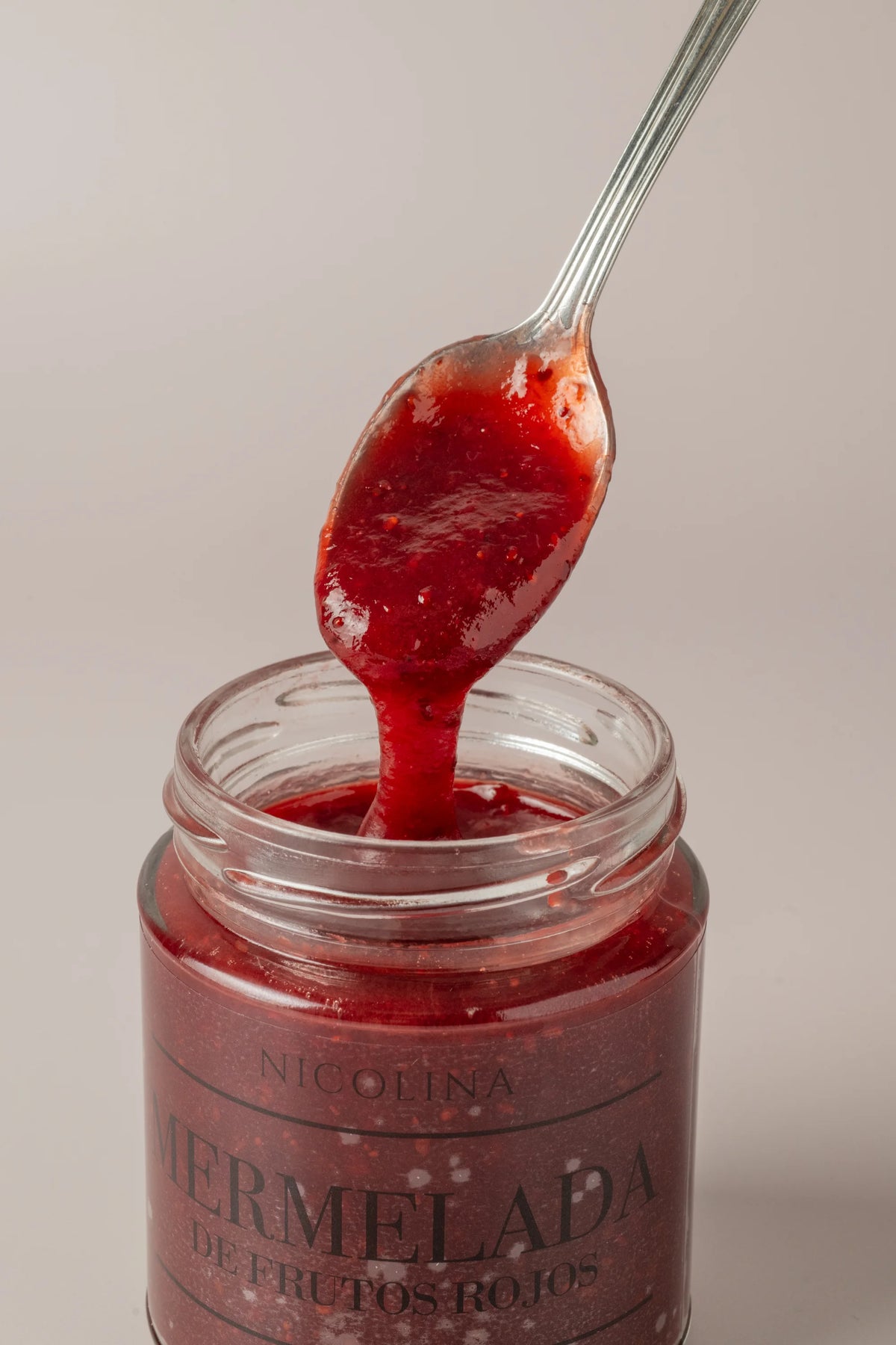 Primer plano de mermelada de frutos rojos sin gluten, sin azúcar y sin lactosa con textura brillante y cremosa.
