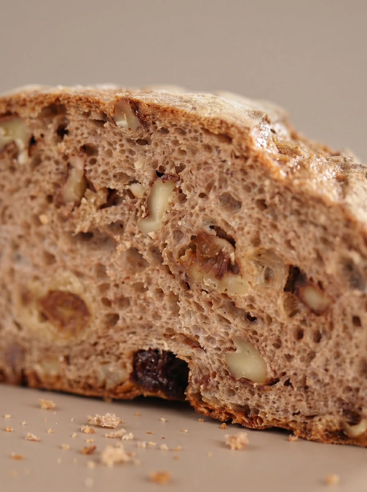 Detalle de la miga de hogaza de pasas y nueces sin gluten y sin lactosa con nueces y textura aireada.
