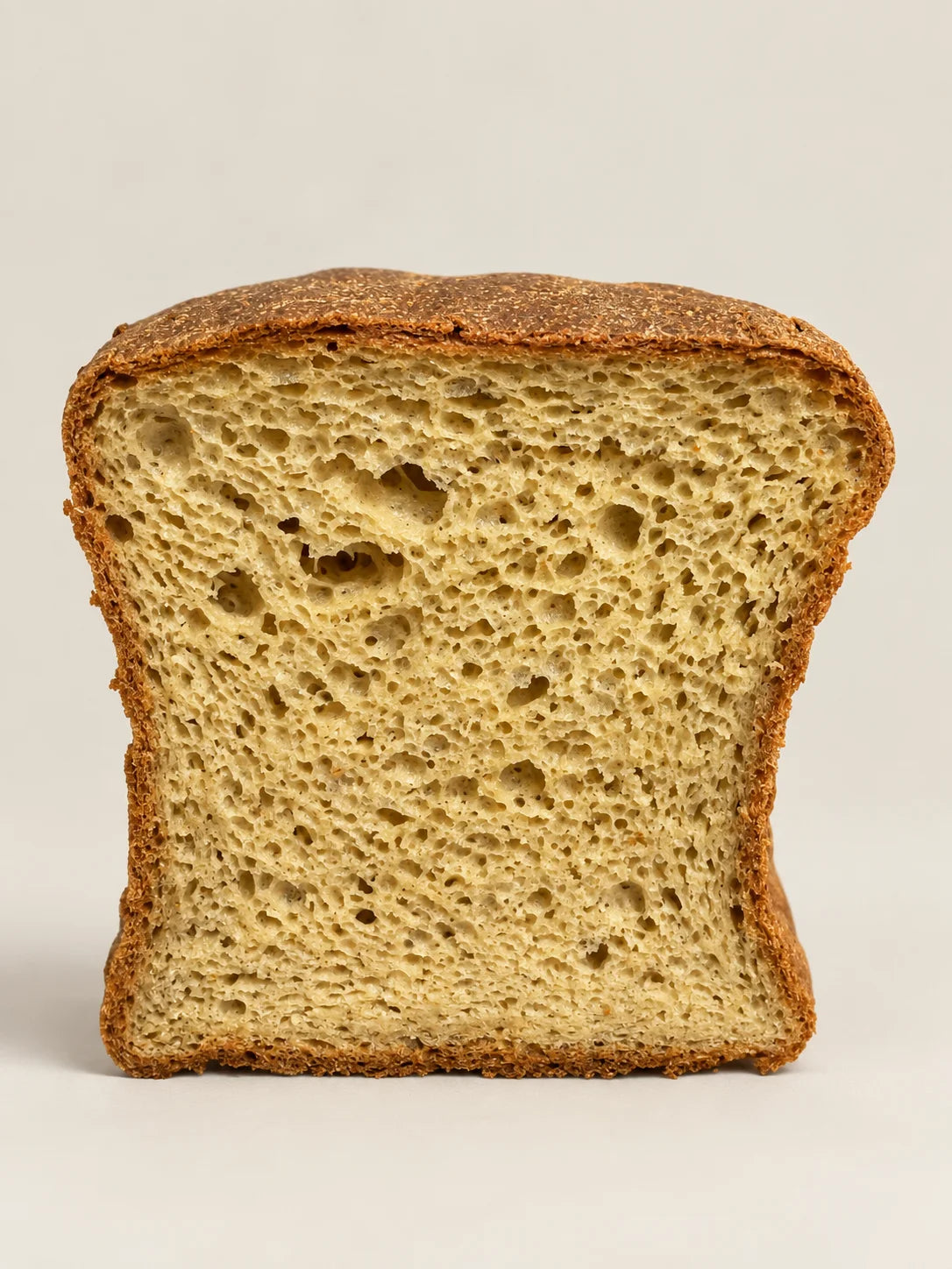 Rebanada de pan de molde sin gluten, sin lactosa y sin azúcar de NICOLINA, mostrando una miga ligera y esponjosa.
