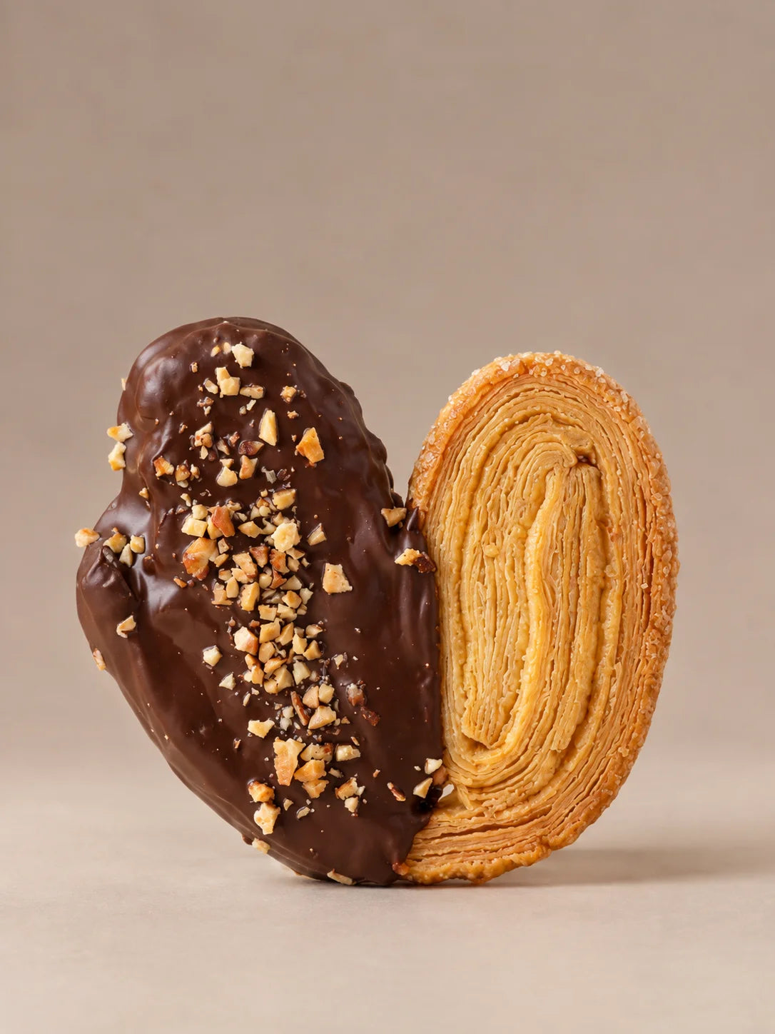 Palmera de chocolate y almendra sin gluten y sin lactosa con hojaldre crujiente y cobertura de chocolate artesanal.
