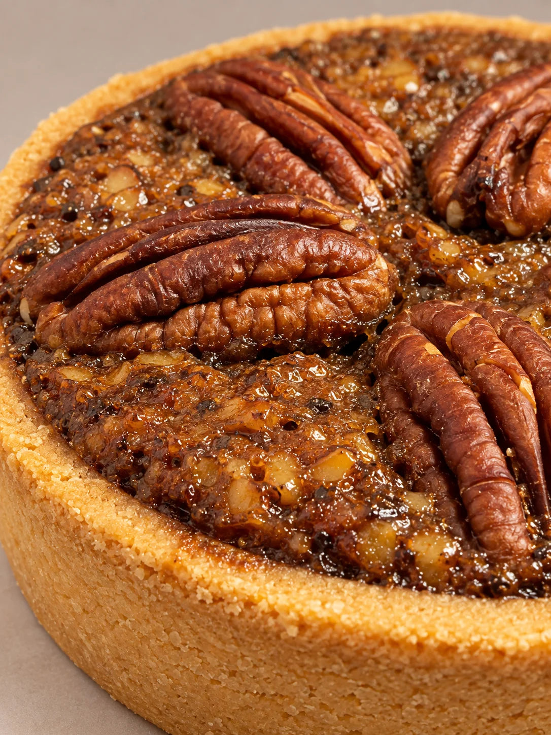Pecan Pie sin gluten y sin lactosa cortada, mostrando el relleno denso de pecanas, caramelo y frutos secos.
