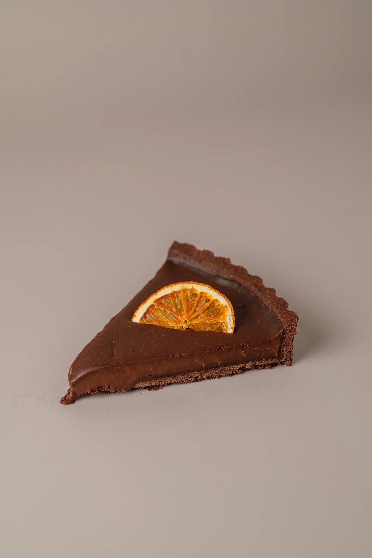 Detalle de tarta de chocolate y naranja sin azúcar de NICOLINA Madrid, con cobertura brillante de chocolate y naranja natural.

