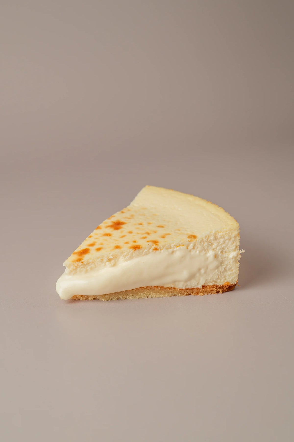 Porción de tarta de queso sin gluten y sin azúcar de NICOLINA Madrid, con interior ultra cremoso y base artesanal.
