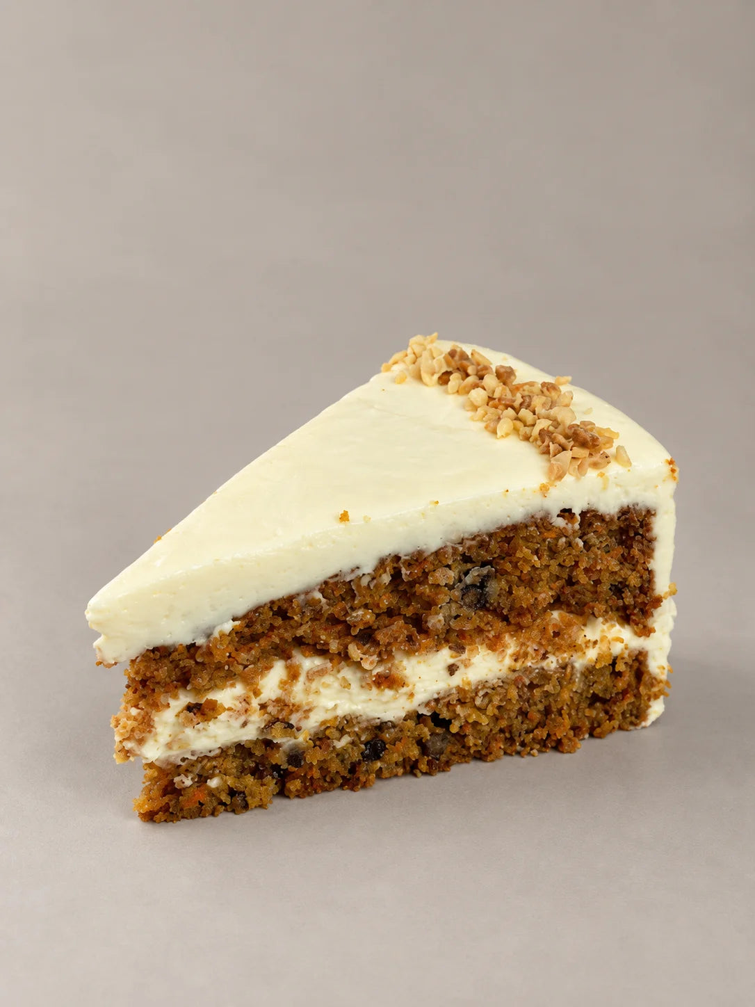Porción de tarta de zanahoria artesanal sin gluten de NICOLINA Madrid, con crema ligera de queso y textura húmeda.
