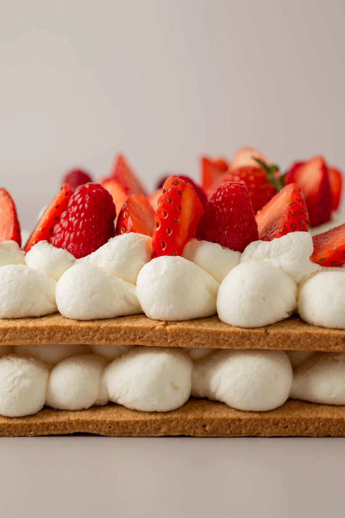 Detalle de tarta número personalizada sin gluten, sin azúcar y sin lactosa decorada con fresas y frambuesas.

