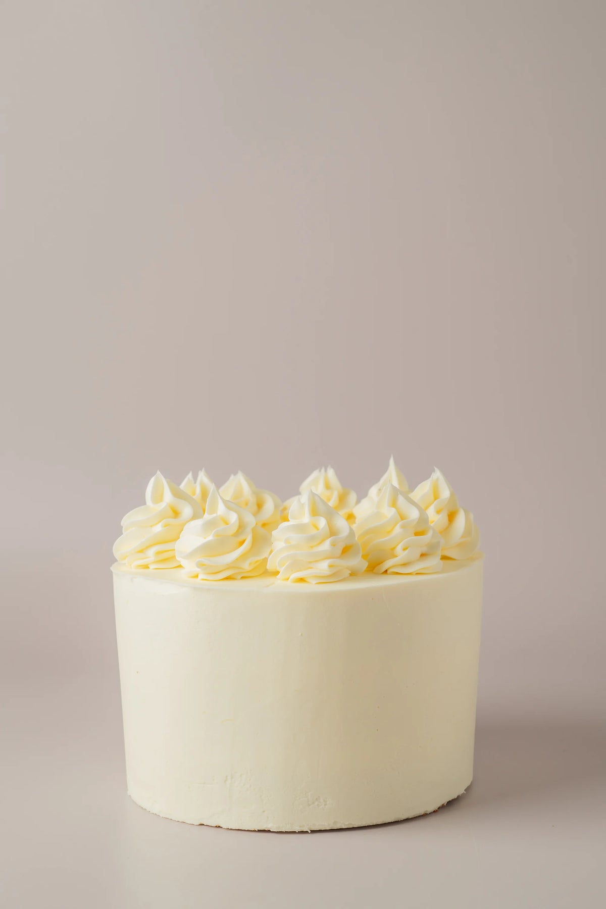 Detalle de tarta de cumpleaños sin gluten y sin azúcar con cobertura cremosa y chocolate fundido.
