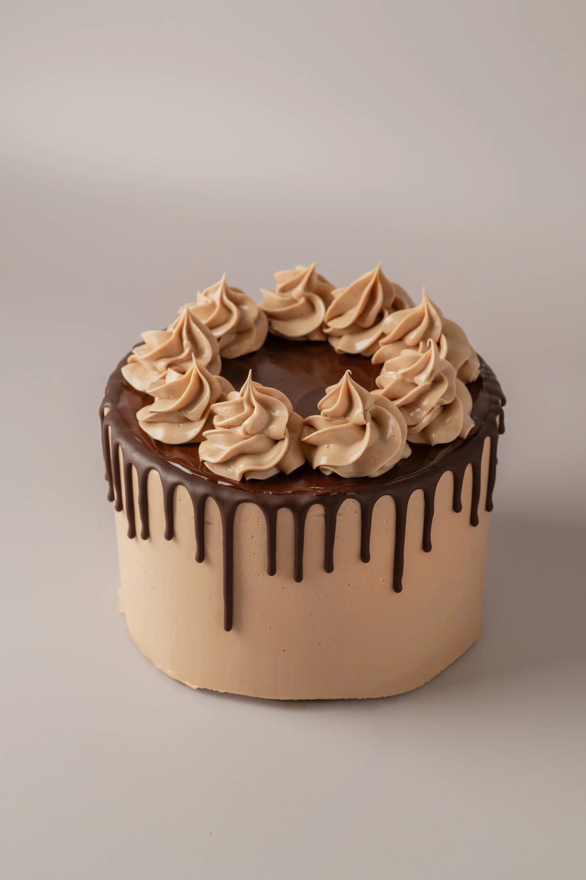 Tarta de cumpleaños de 20 porciones sin gluten y sin azúcar con cobertura de chocolate y crema decorativa.
