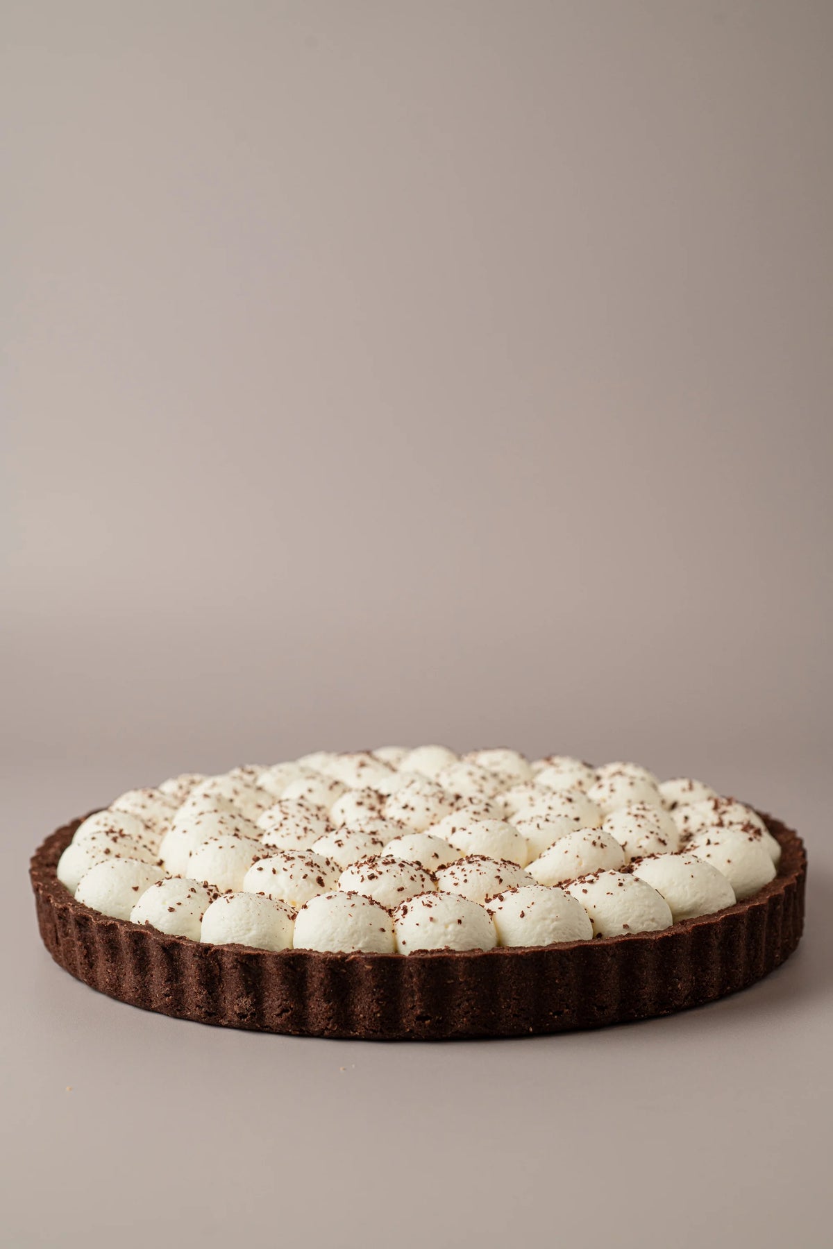 Tarta de chocolate y nata artesanal sin gluten, sin lactosa y sin azúcar añadido de NICOLINA Madrid con base sablé de cacao y nata montada.
