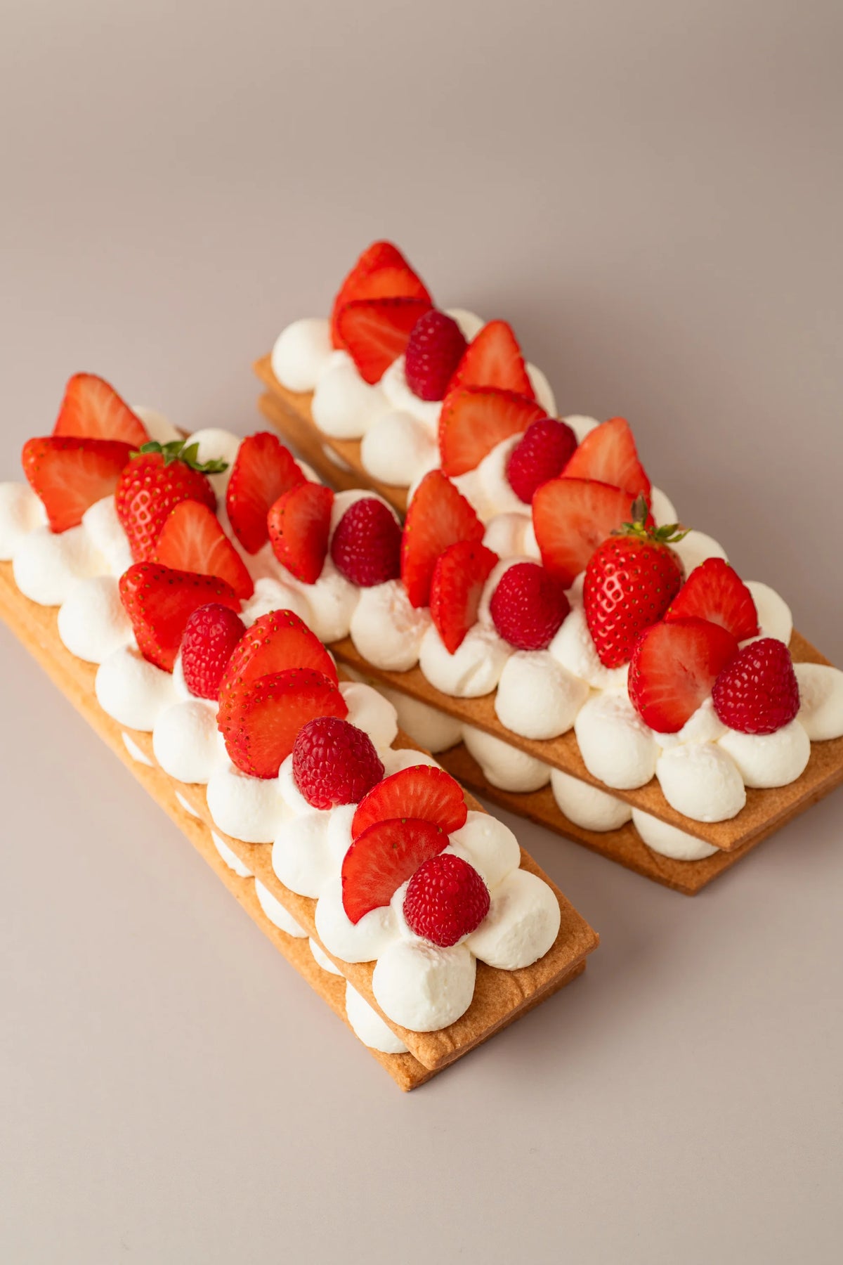 Tarta letra de fresa sin gluten, sin azúcar y sin lactosa con crema suave, fresas y frambuesas frescas de NICOLINA Madrid.
