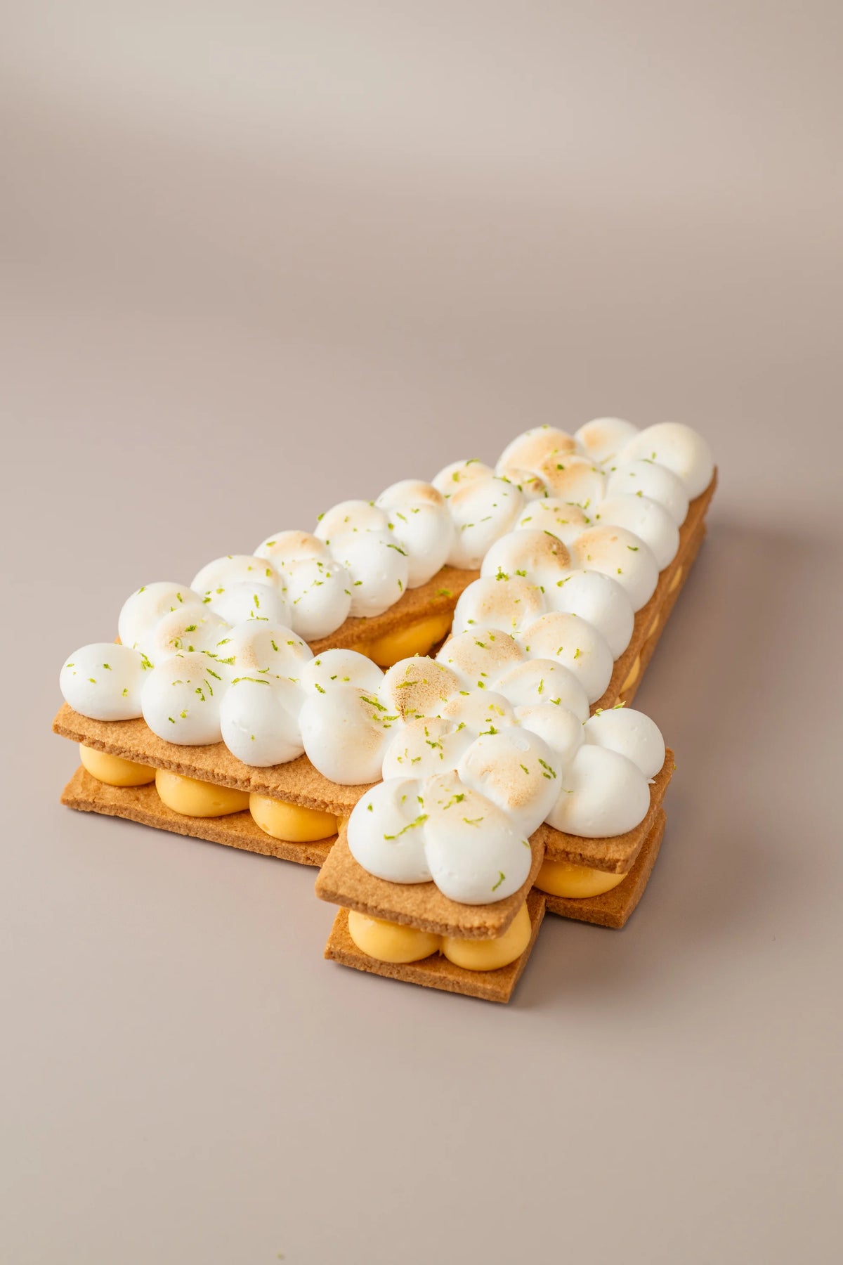 Tarta número de limón sin gluten, sin azúcar y sin lactosa con merengue tostado y crema artesanal de limón.
