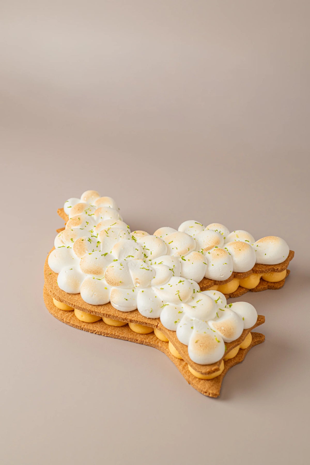 Tarta paloma sin gluten, sin azúcar y sin lactosa con crema de limón, merengue tostado y decoración artesanal de lima.
