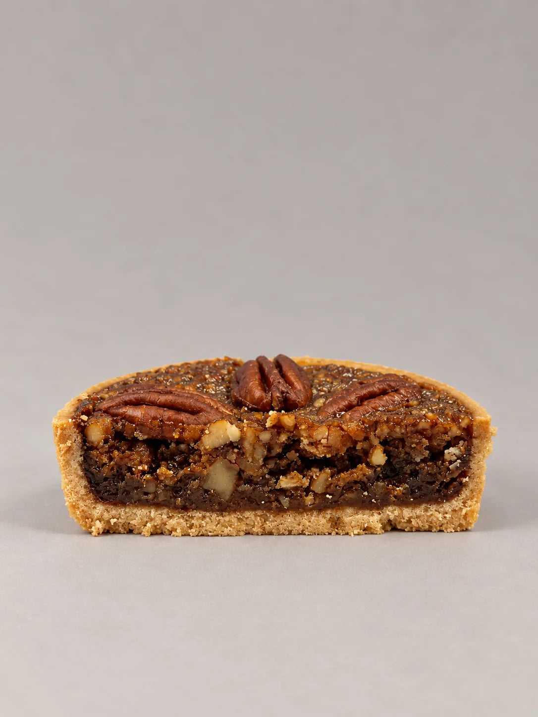 Pecan Pie sin gluten y sin lactosa, vista completa, con nueces pecanas tostadas sobre un relleno brillante de caramelo.
