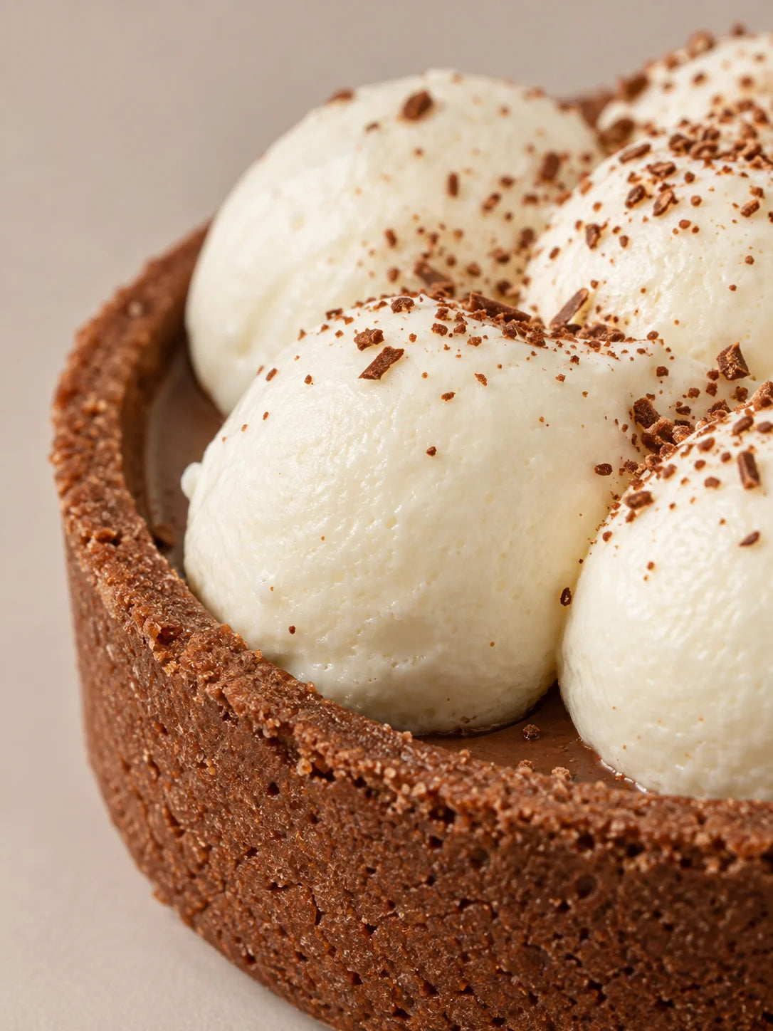 Detalle de tartaleta de chocolate y nata sin gluten, sin lactosa y sin azúcar con crema ligera y base crujiente de cacao.
